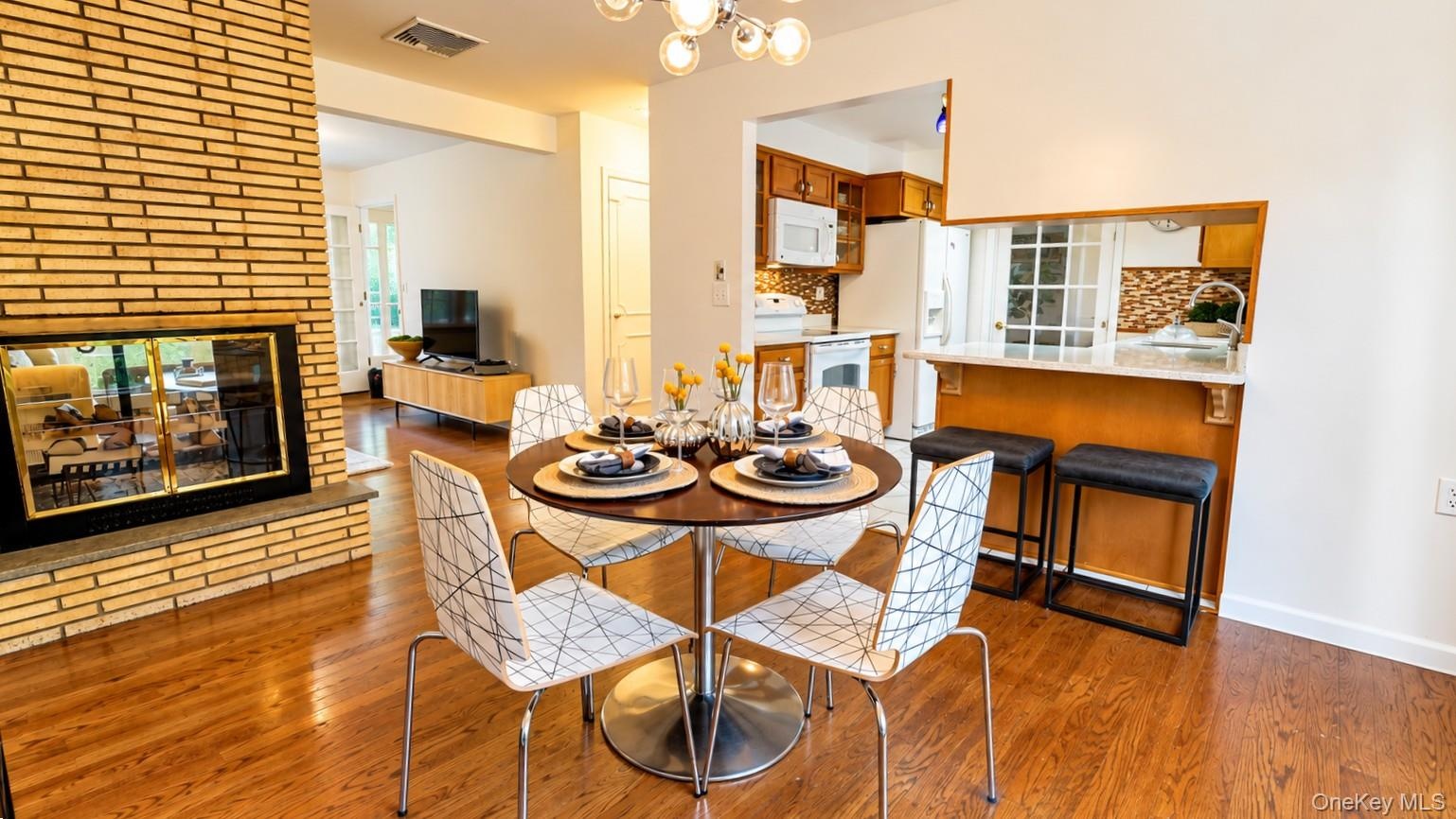 The inviting eat-in kitchen features a cozy wood-burning fireplace, convenient access to the kitchen, and sliding glass doors leading to the backyard,