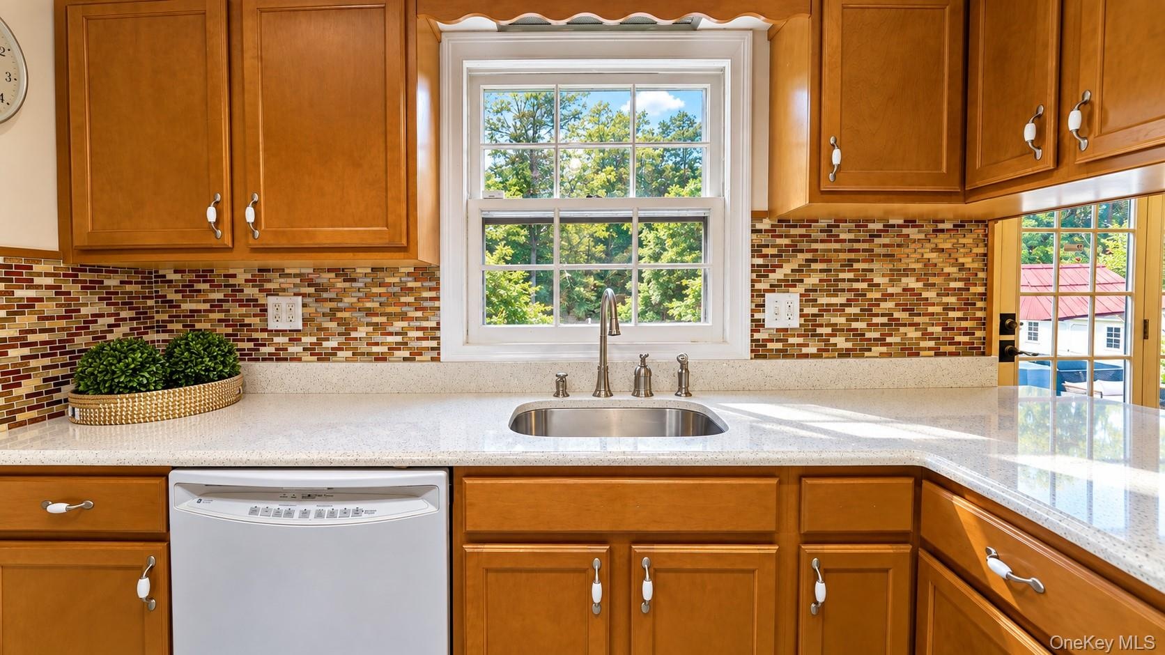 The well-appointed kitchen features stylish accent lighting, a beautiful tile backsplash, and durable tile flooring, combining functionality with time