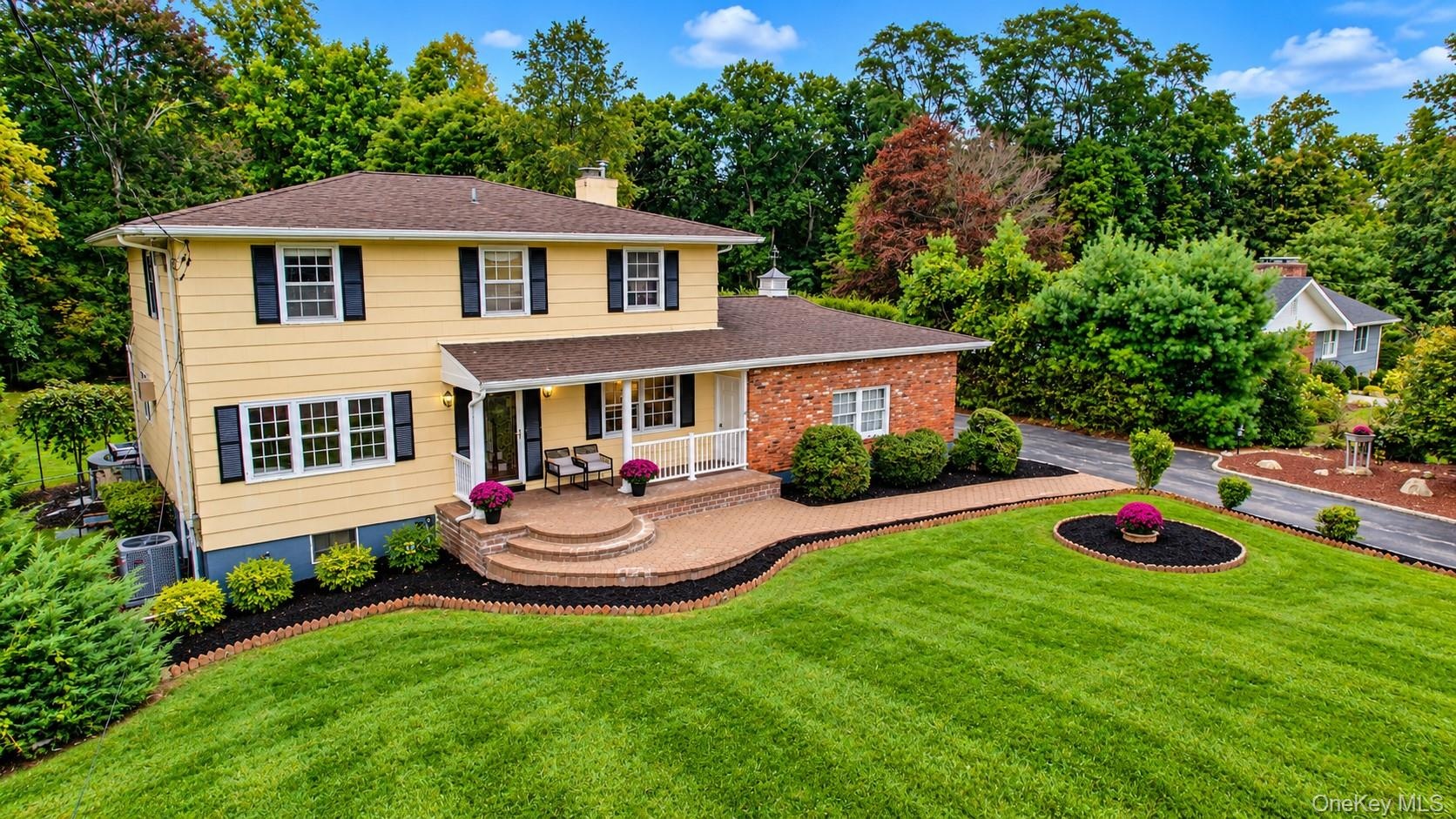 This spectacular home is beautifully complemented by lush landscaping, mature plantings, and an expansive front yard, creating a warm and inviting fir