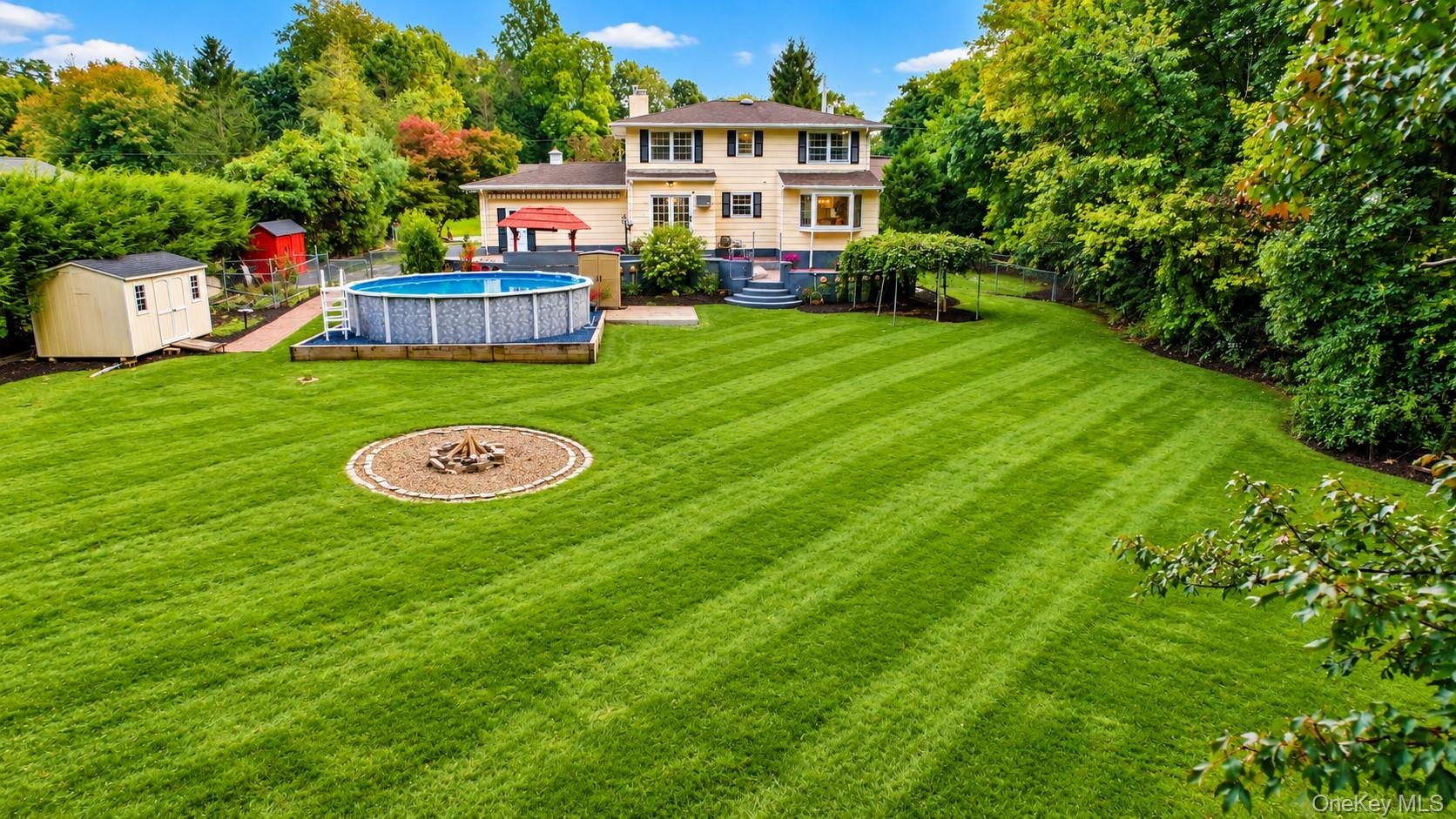 The expansive backyard is a true oasis, offering plenty of room for kids and pets to roam, play, and enjoy the outdoors. With generous open space and 