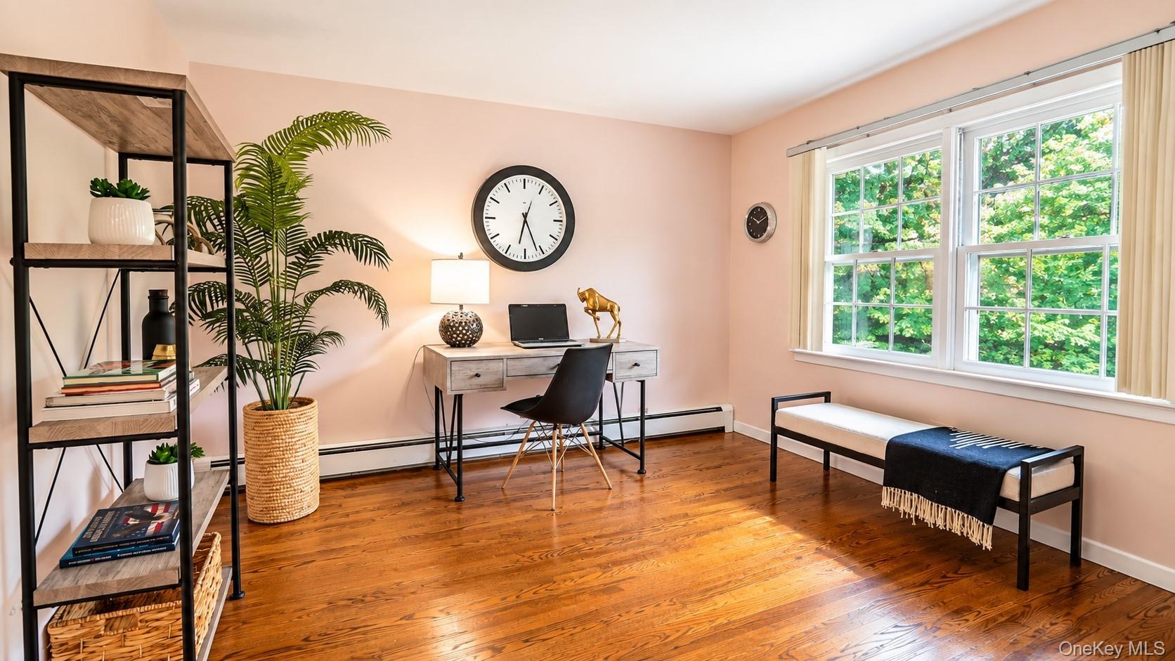 Another beautiful view of this inviting fourth bedroom, featuring double windows that fill the space with natural light, custom built-ins, and a gener