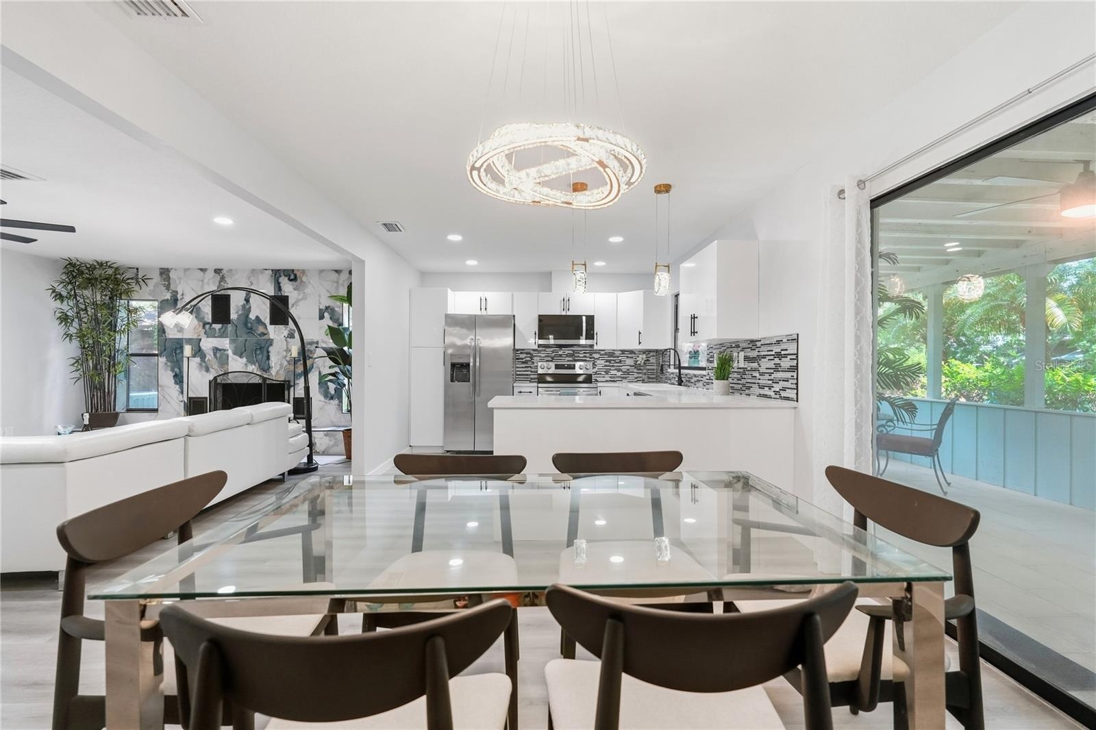 Spacious Dining Area adjacent to Large Sliders, Lanai, and Lush Landscaping.