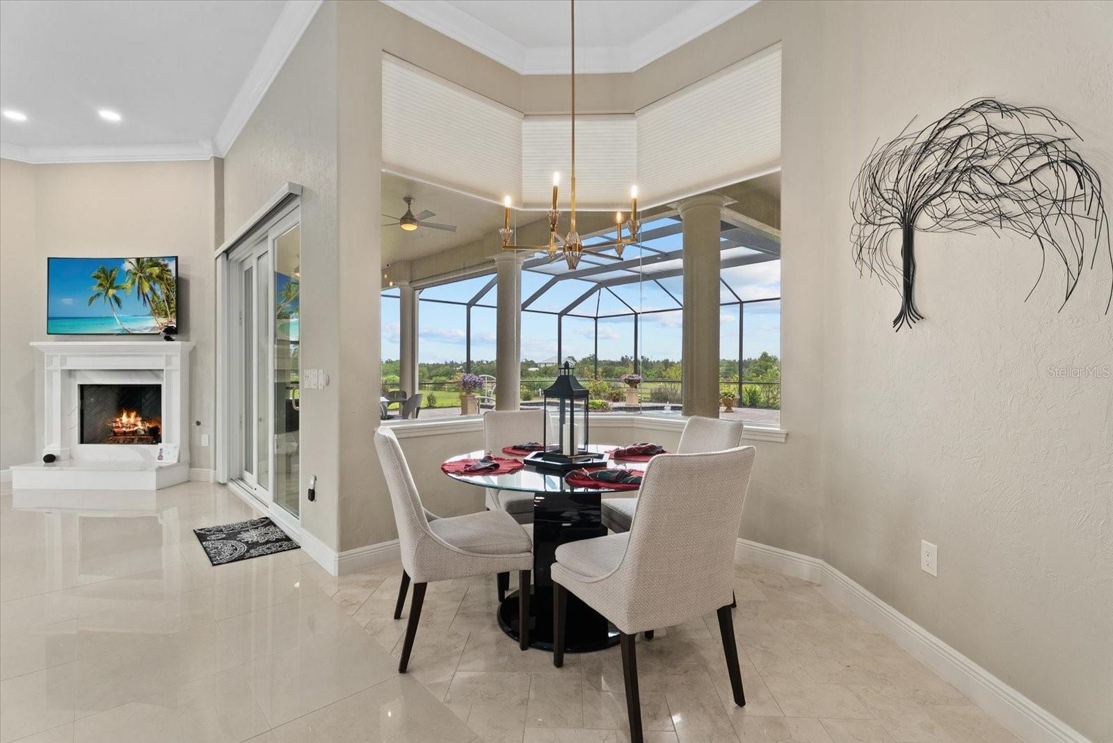 The breakfast nook is surrounded by aquarium glass windows looking out on the pool deck and pastures