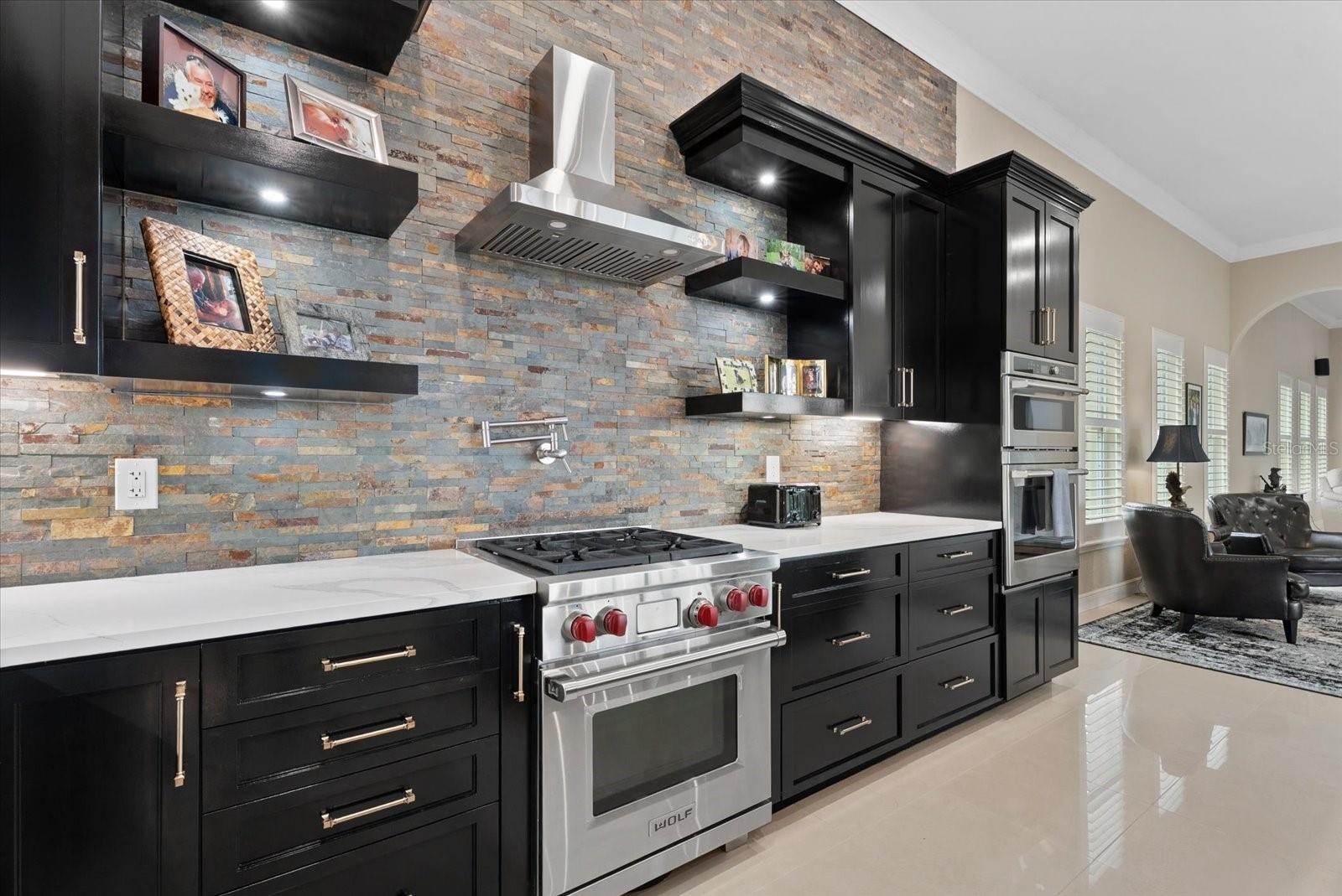 The home offers a gas range/cooktop, built-in oven and microwave with marble countertops