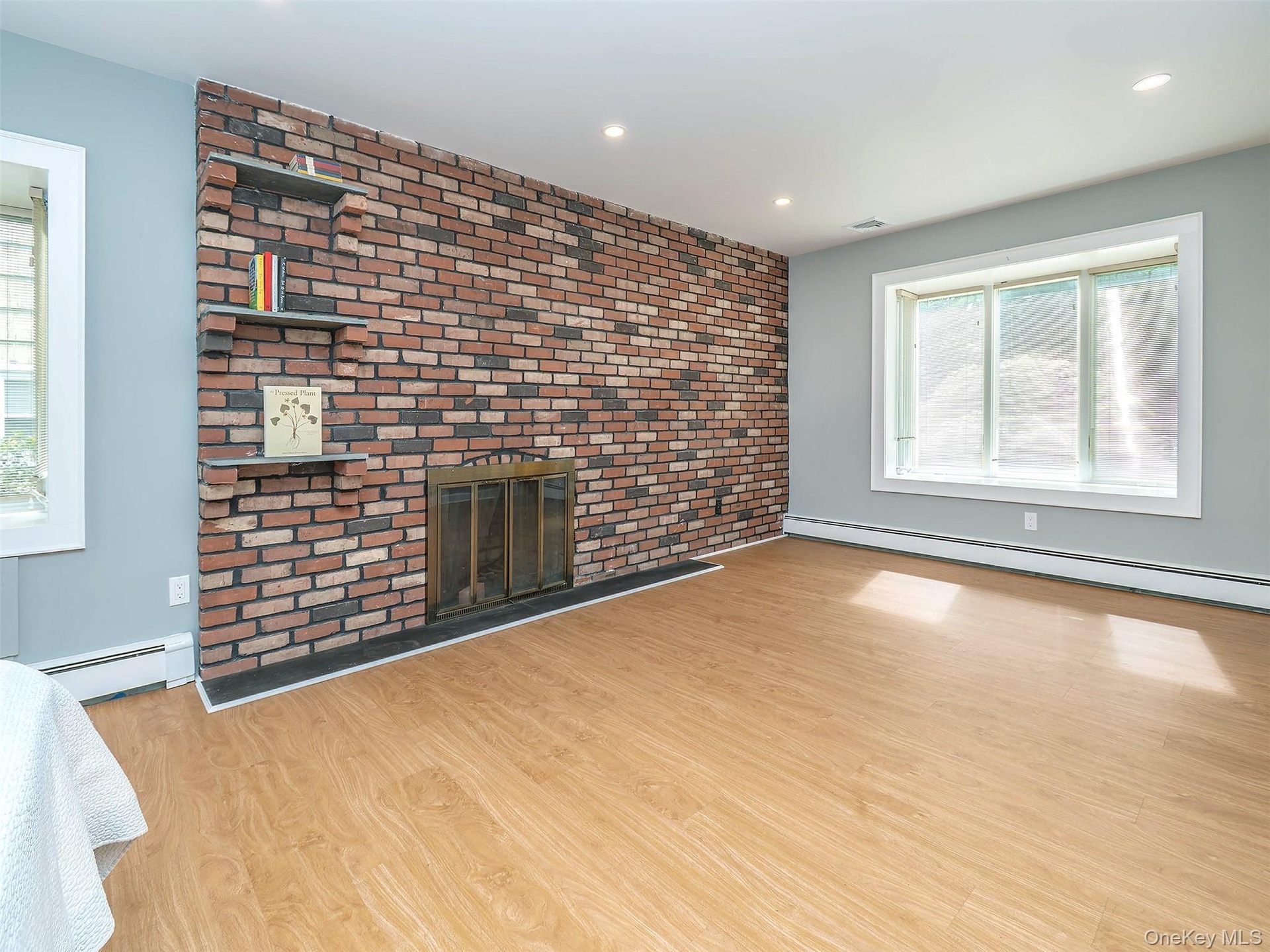1st floor: Primary bedroom with wood burning fireplace on brick wall with 3 stone shelves.