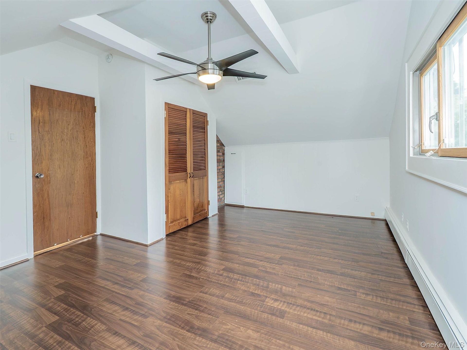 2nd floor: Bedroom #3 showing vinyl flooring , beams & closet.