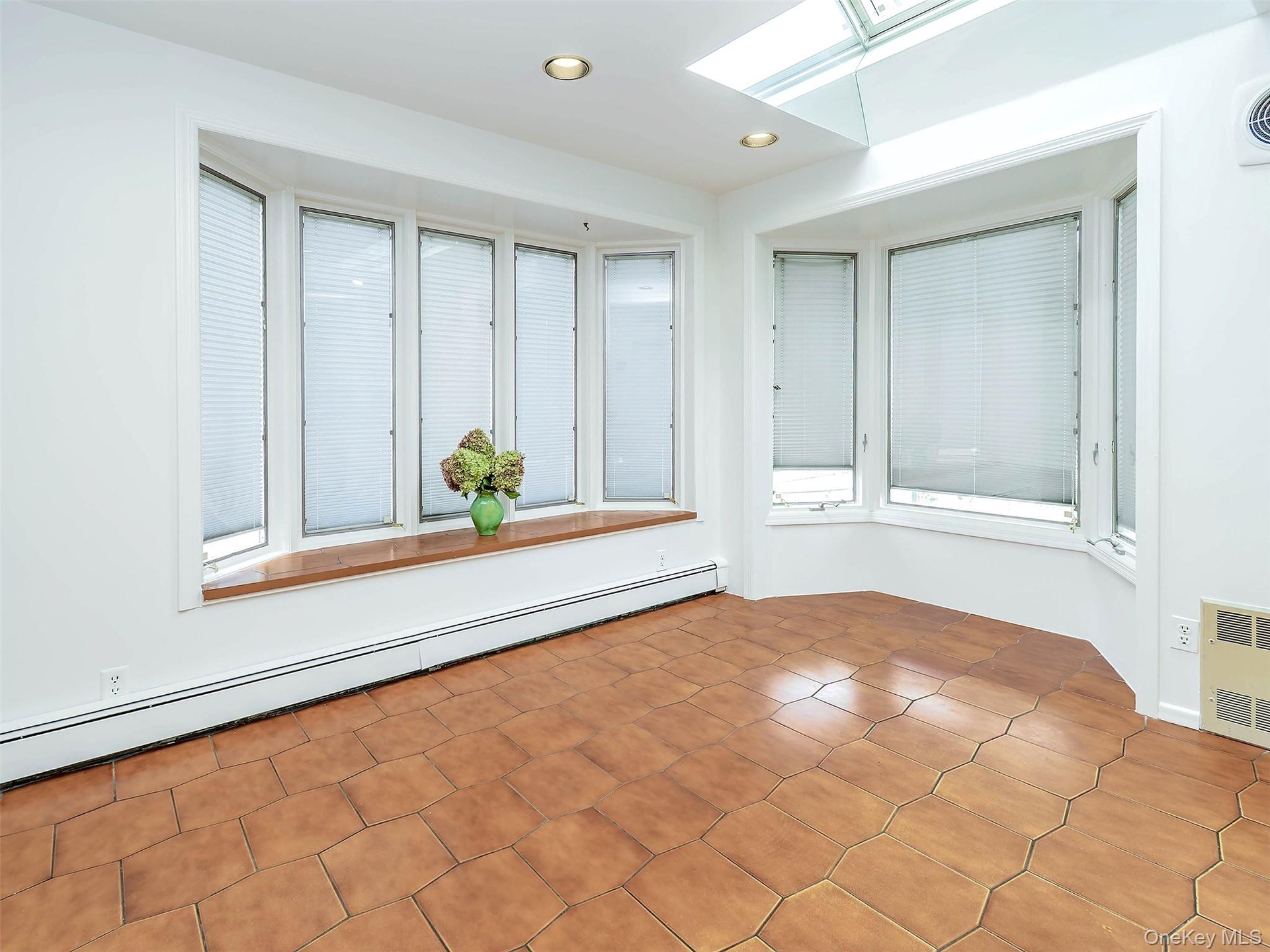 Window seat on one of the bay windows. Room for your kitchen table. Skylight above.
