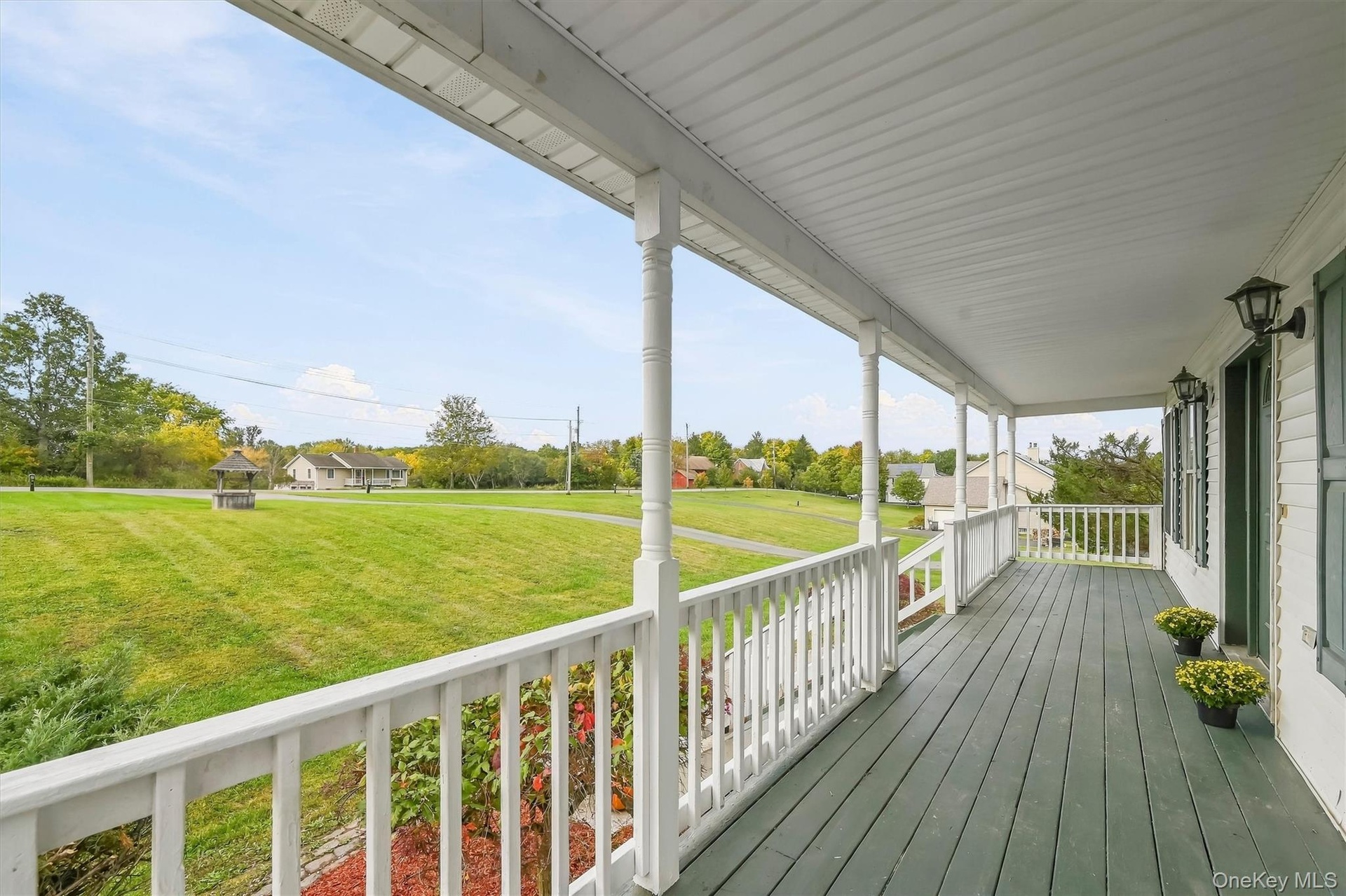 This full-length covered porch is built for coffee in the morning and quiet evenings overlooking the property.