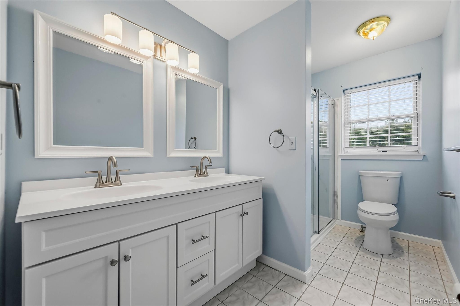 The private en suite features a double vanity and a crisp, updated look.