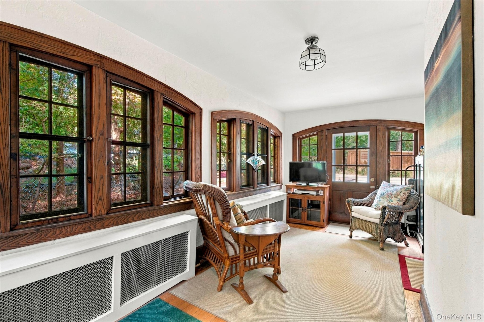 4-Season Sun Room with wall of arched windows and doorway.