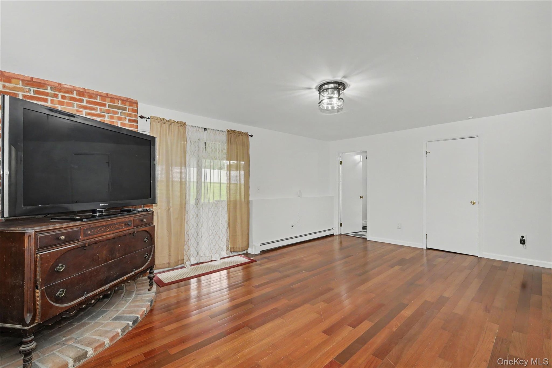 Huge family room with bricked platform for woodburning stove and glass sliders to backyard