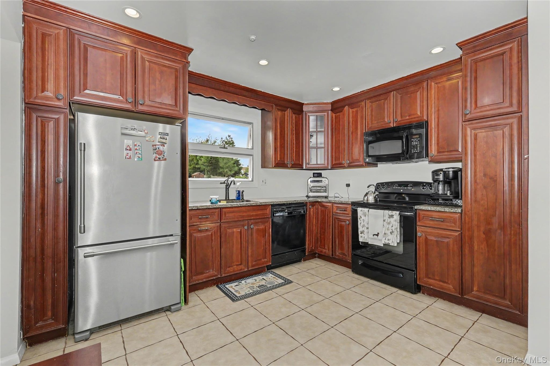 Well equipped and ample kitchen featuring wood cabinetry, recessed lighting, tile flooring and pantry
