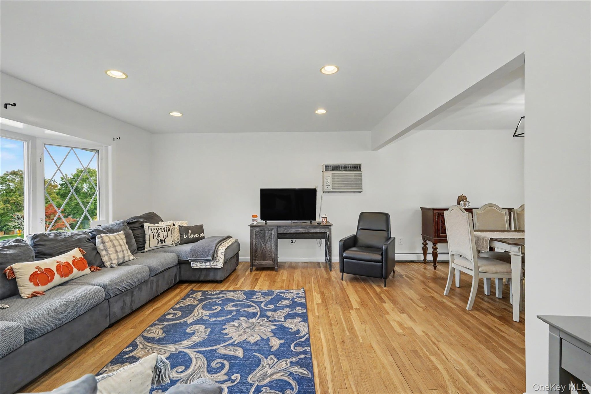 Spacious living room with a large bay window for great natural light and wood flooring