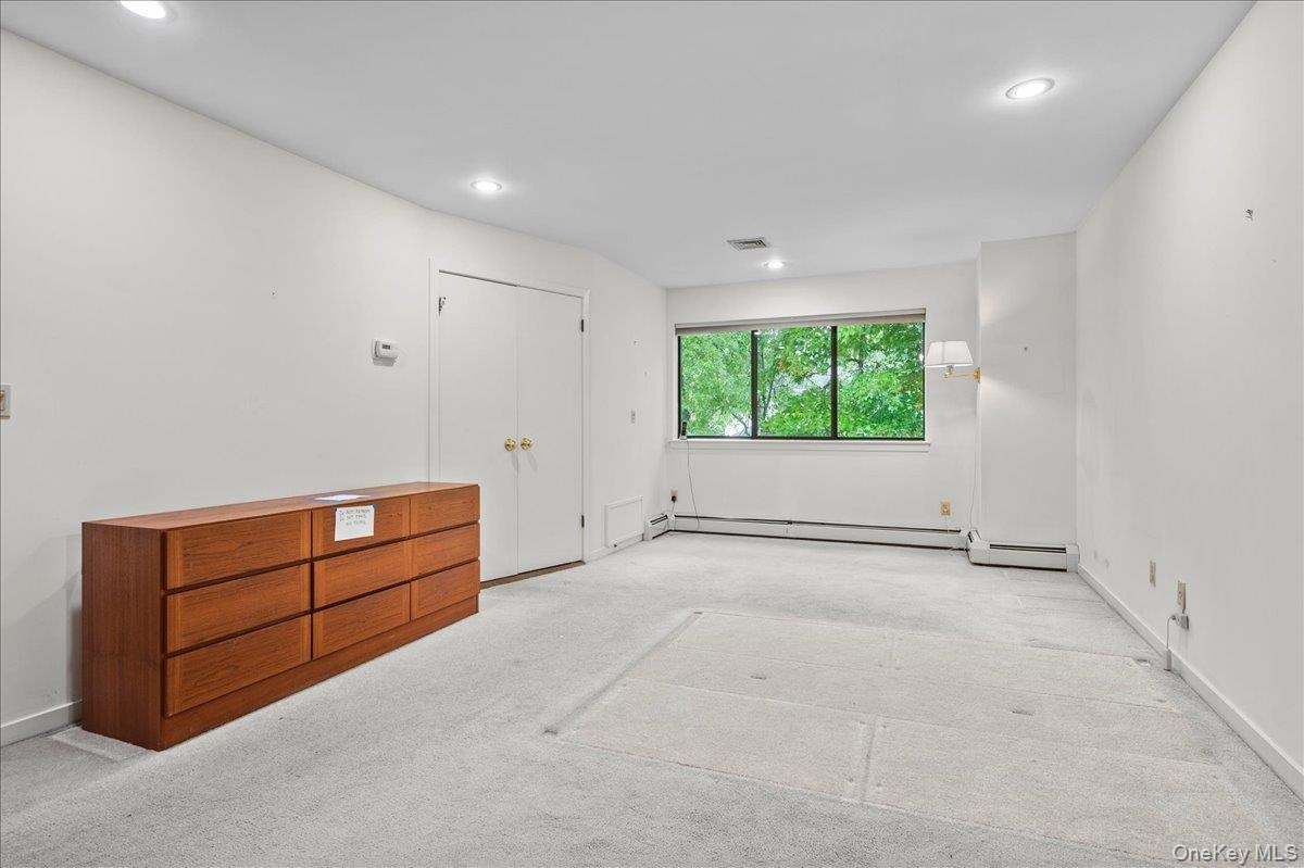View from the reach-in closet emphasizing how large bedroom is, with doors leading to the primary bathroom