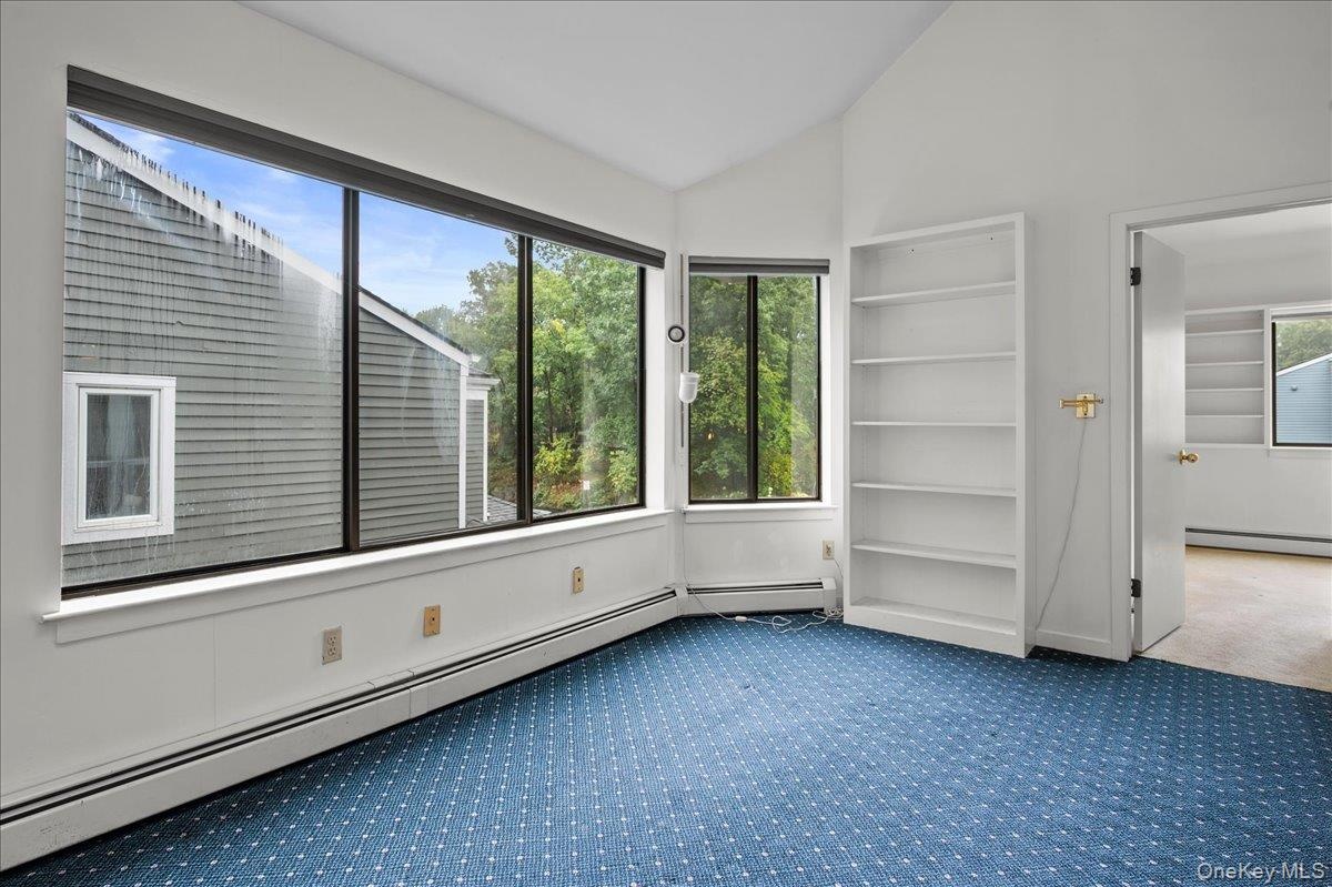 View of the den on the second floor leading to the bedroom, full bath and wall-to-wall windows