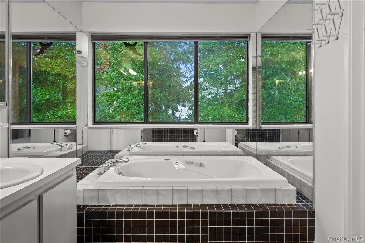 View looking out to wall-to-wall windows and a spa tub