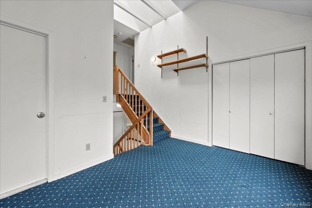 View of the den/family-room closet steps leading up to the laundry room and primary bedroom