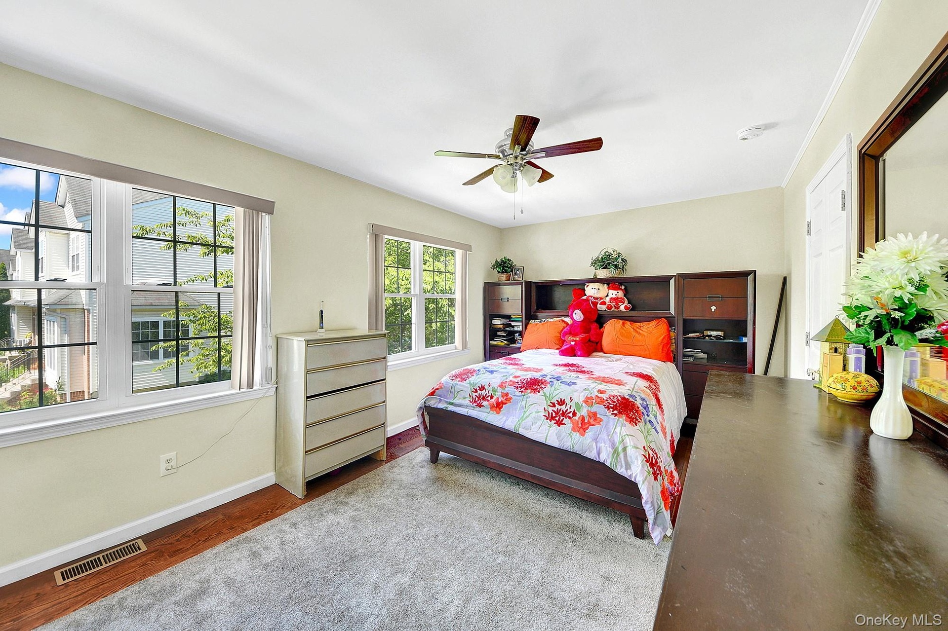 Primary bedroom with large windows, large closets, hardwood floors and an en-suite bathroom