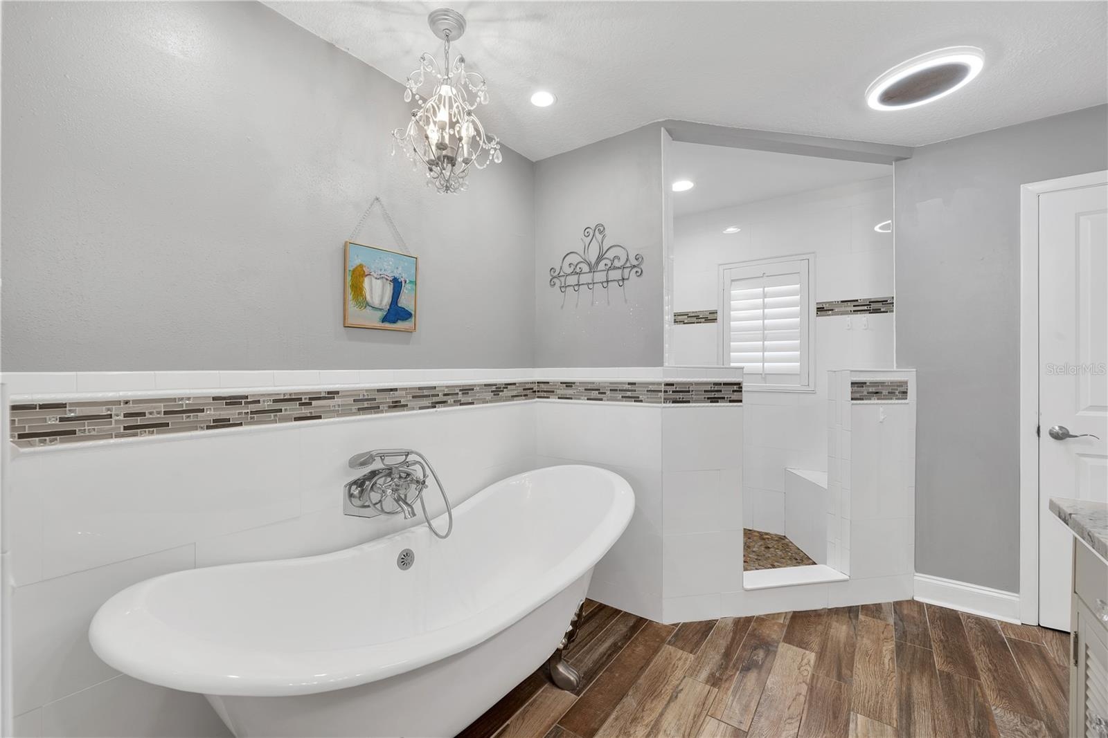 Stunning modern clawfoot tub, corner shower with multiple showerheads and bench in Owner's ensuite.