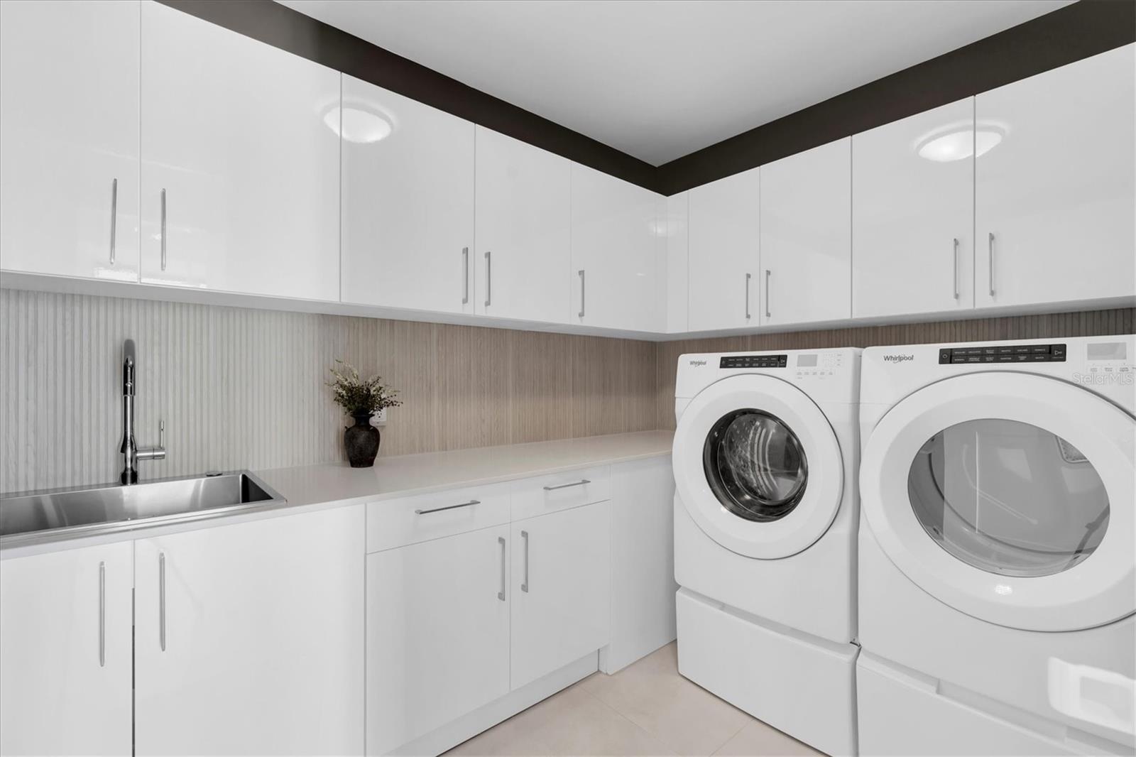 Dedicated laundry room with built-in cabinets.