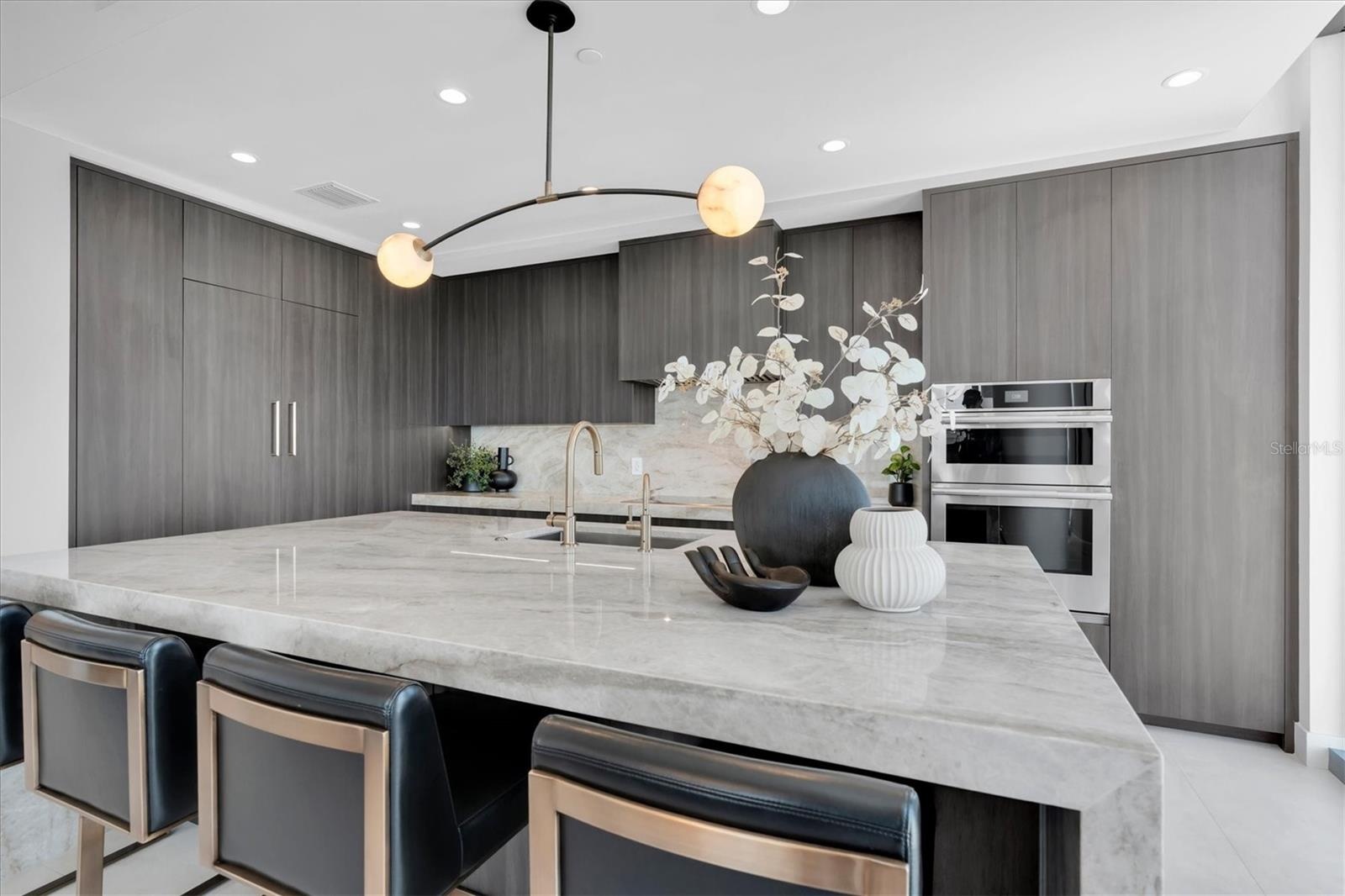 Gourmet kitchen 3" mitered Taj mahal countertops with waterfall on both edges of the island.