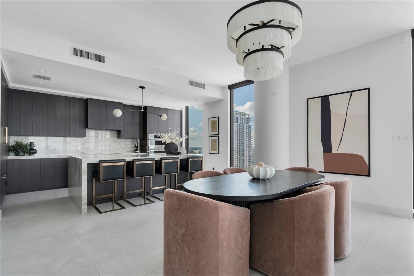 Designer dining area framing quartz waterfall island.