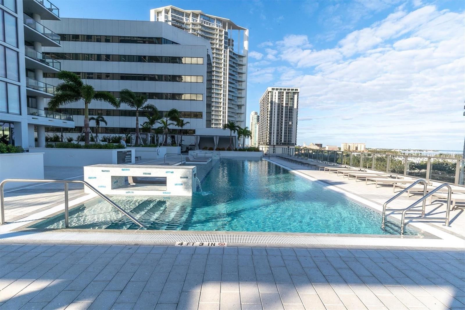 Resort swimming pool with tropical landscape backdrop.