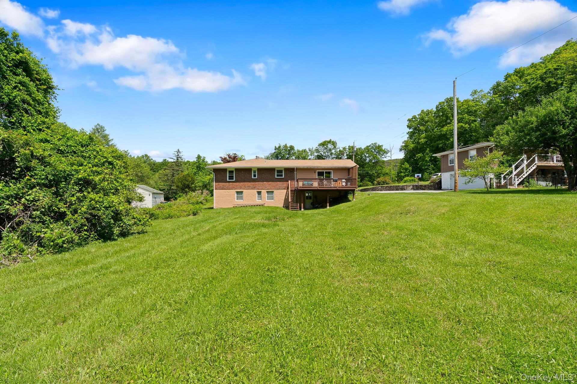 View of green lawn with stairway and a wooden deck