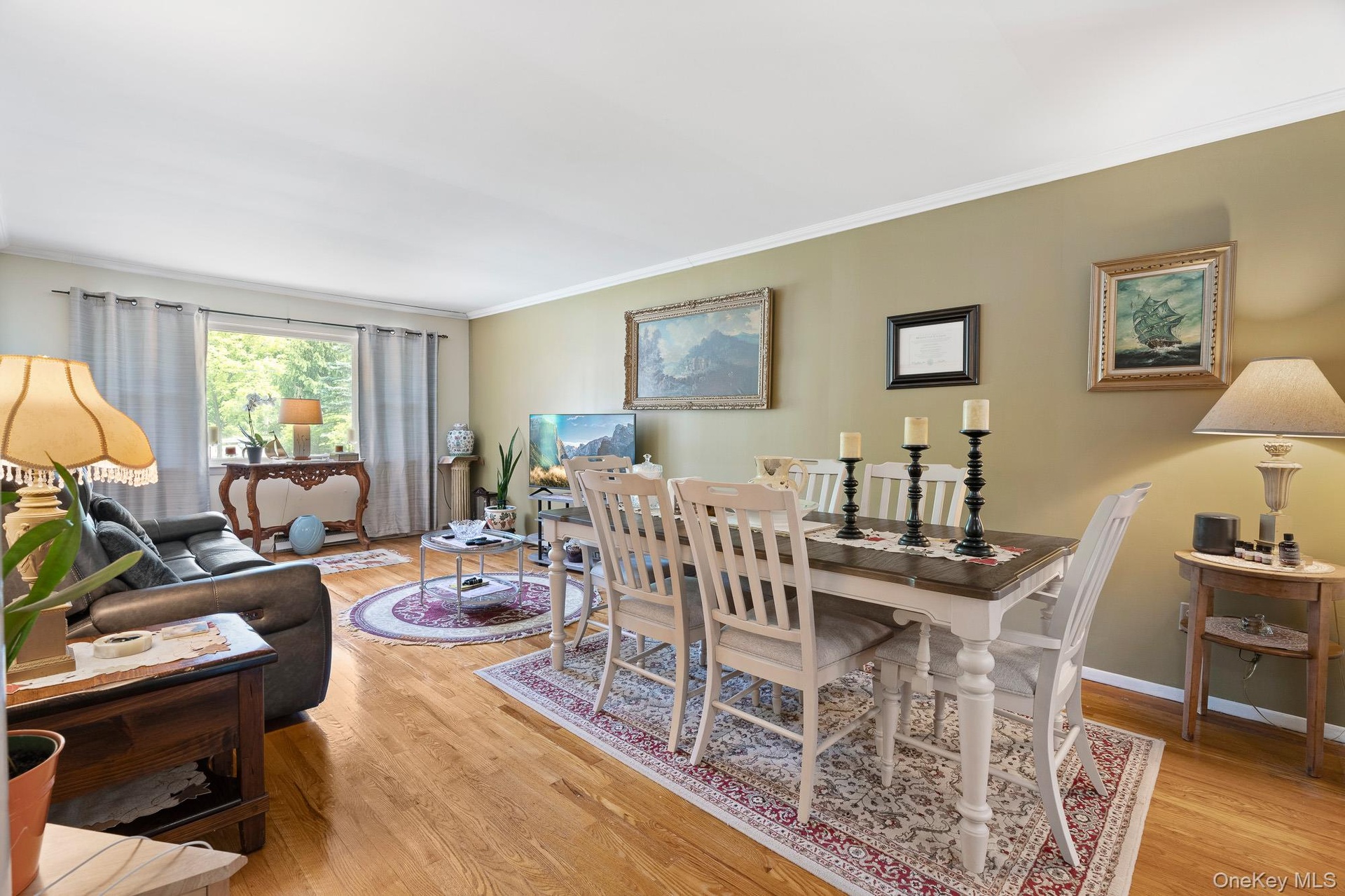 Dining room featuring wood finished floors, ornamental molding, and baseboards