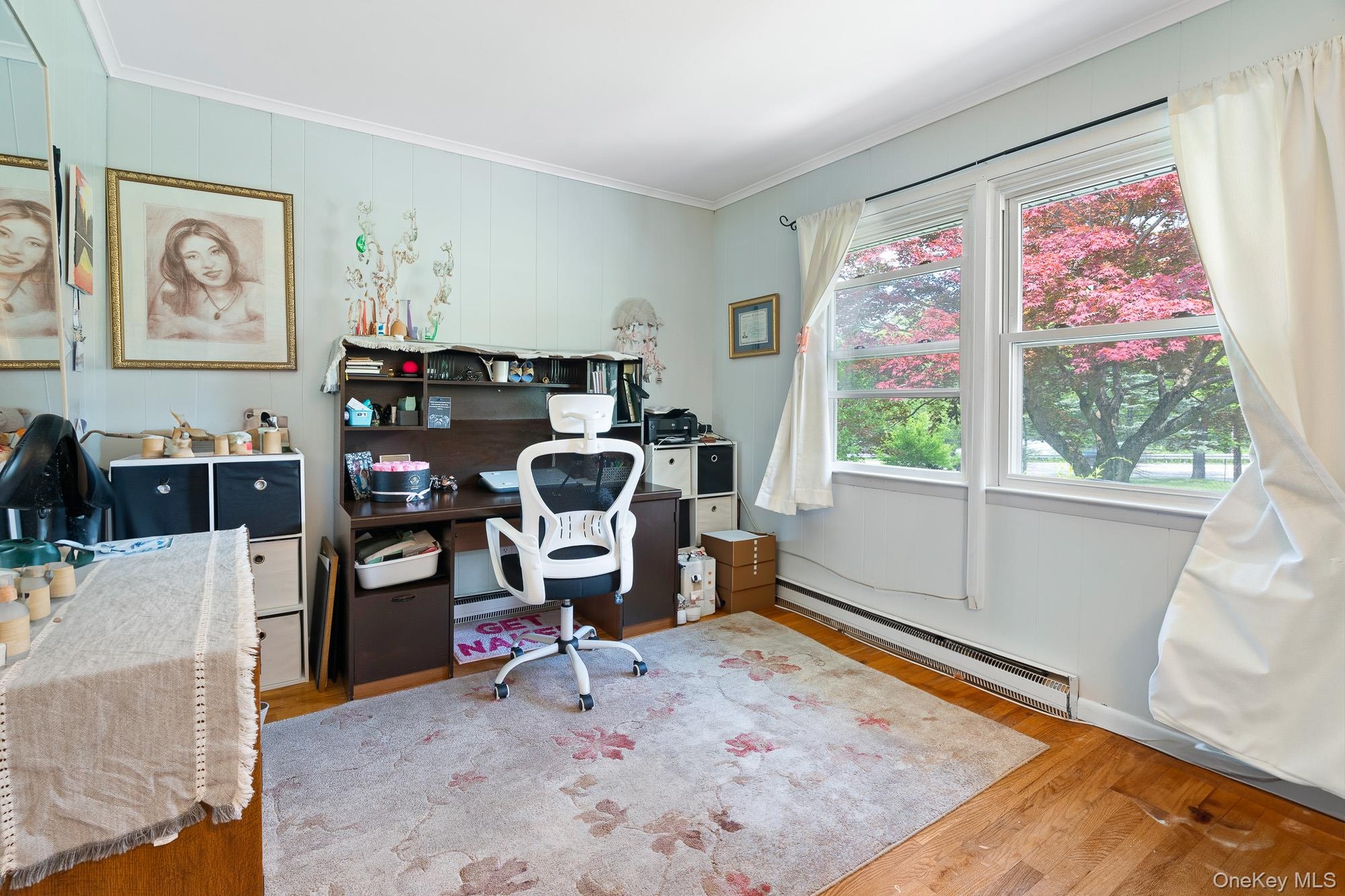 Office area with a baseboard radiator, wood finished floors, and crown molding