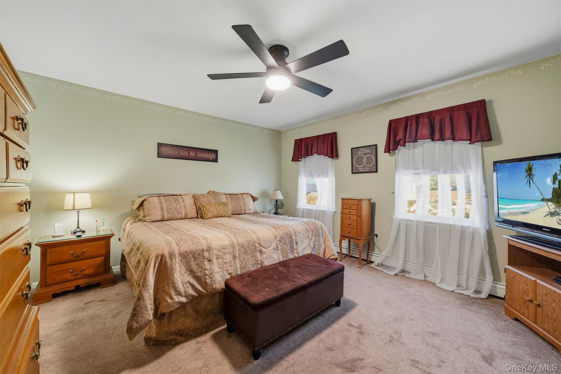 Carpeted room featuring a ceiling fan with integrated lighting, two windows, and light-toned walls