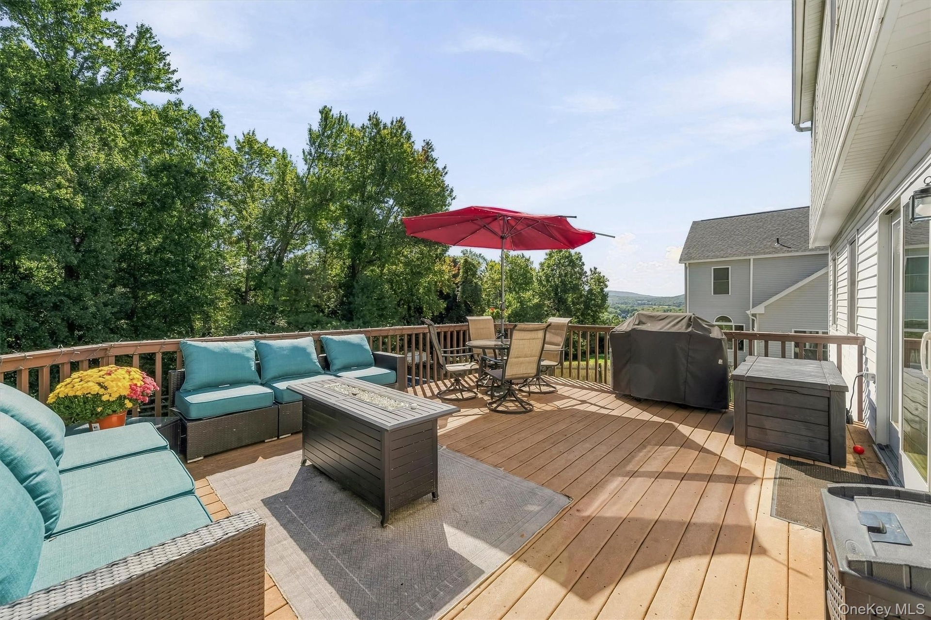 Spacious outdoor deck with wood railing, offering expansive open-air living