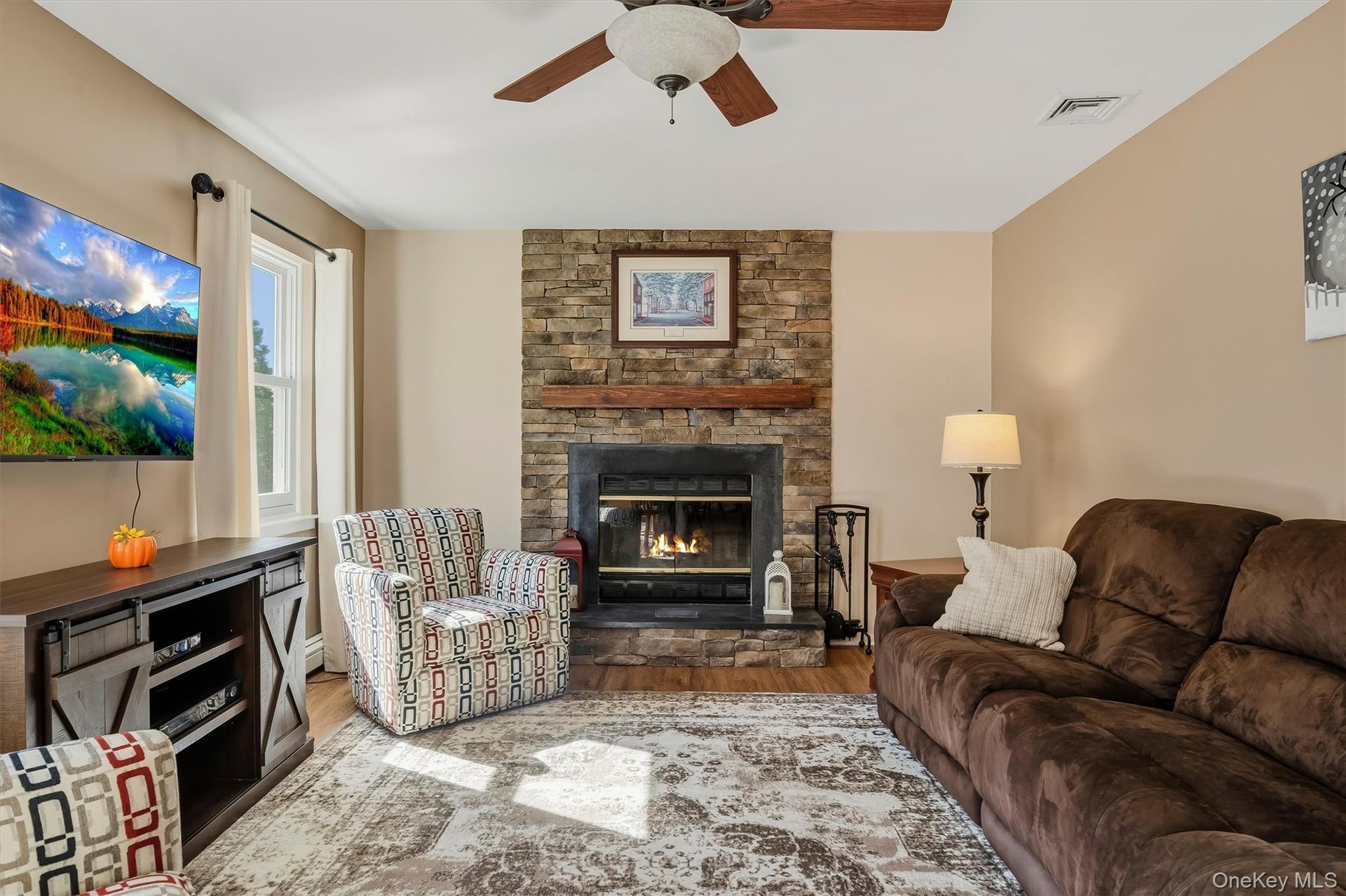 Stone fireplace featuring a wood mantel