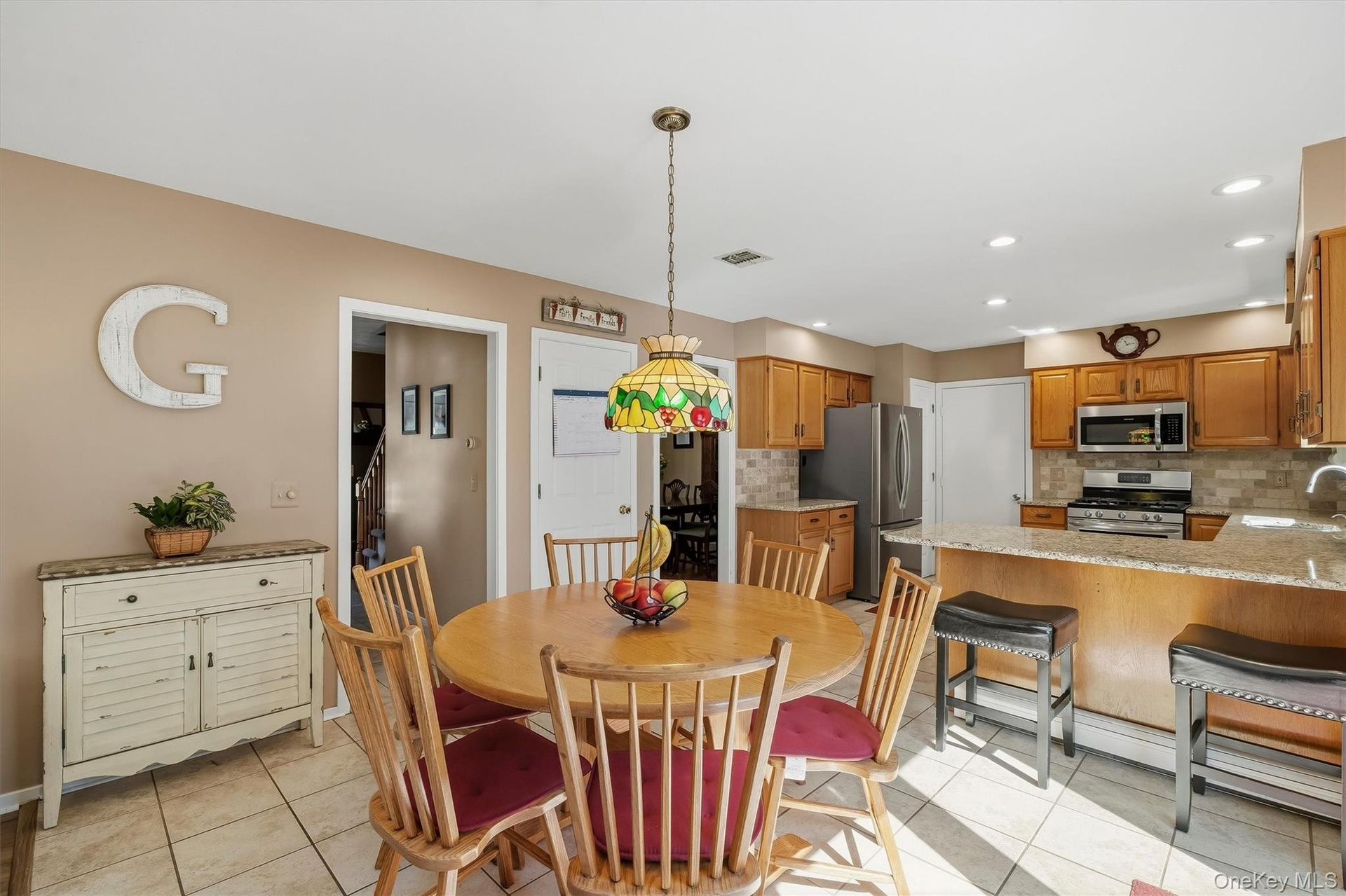 Kitchen featuring wood cabinetry, stainless steel appliances, and a tiled backsplash