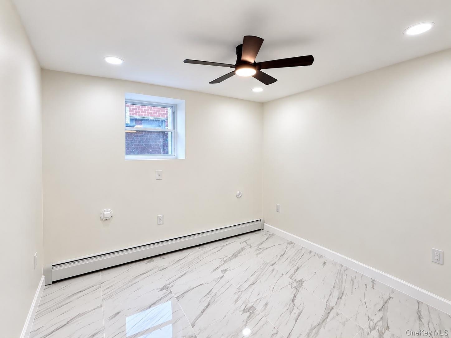 Recessed lighting, ceiling fan, single window, baseboard heating, and tile flooring with a marble-like pattern