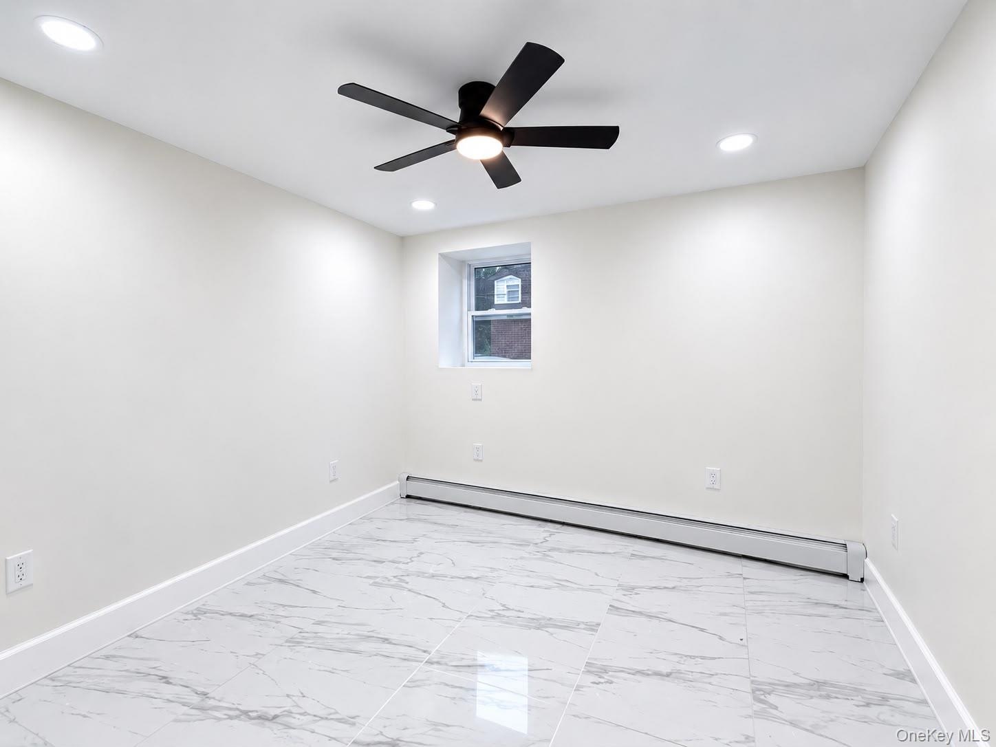 White walls, recessed lighting, ceiling fan with integrated light, marble-look tile flooring, and a baseboard heating unit