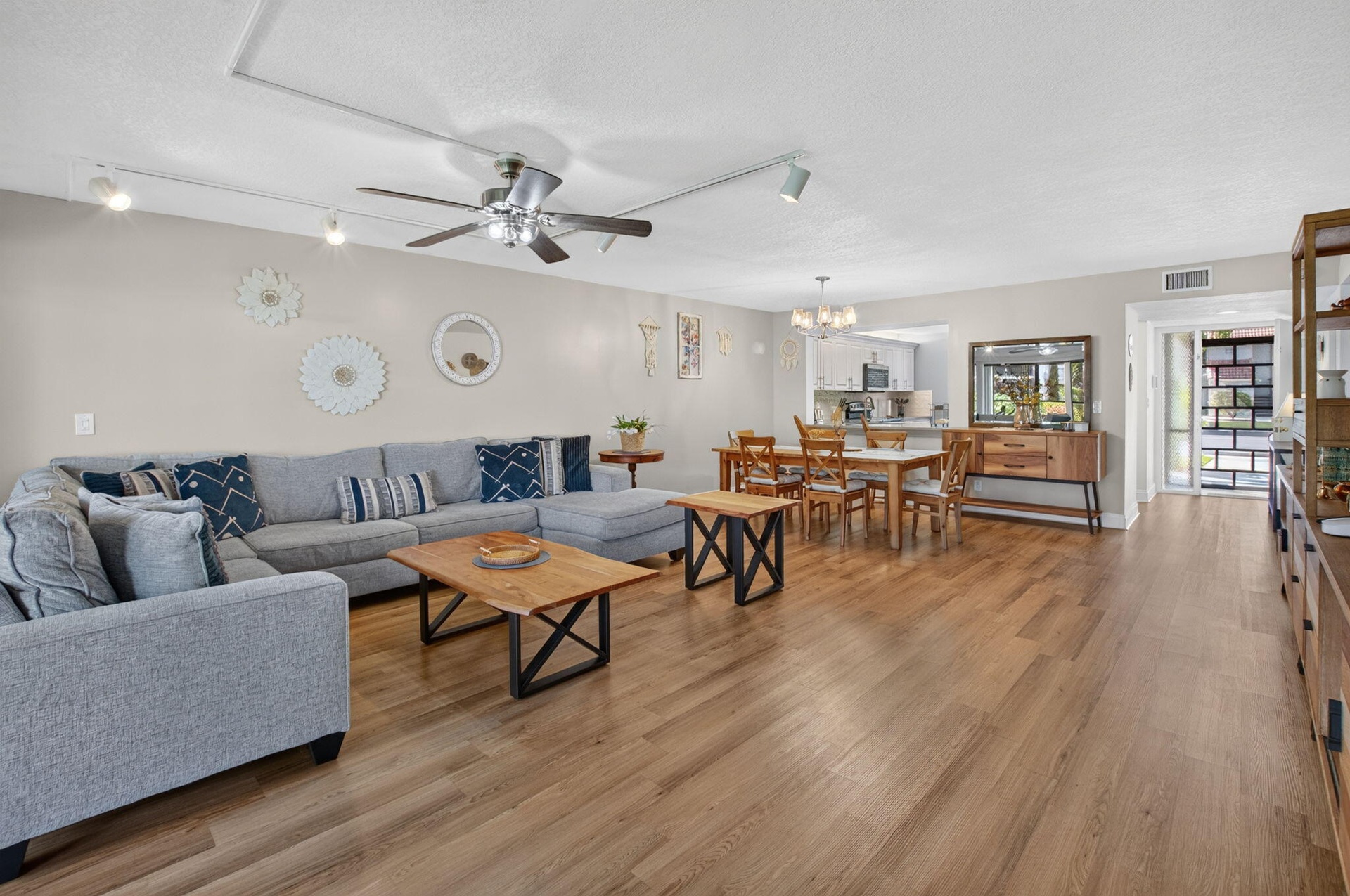Spacious open-concept living area featuring wood-finish flooring, recessed lighting, and ceiling fan