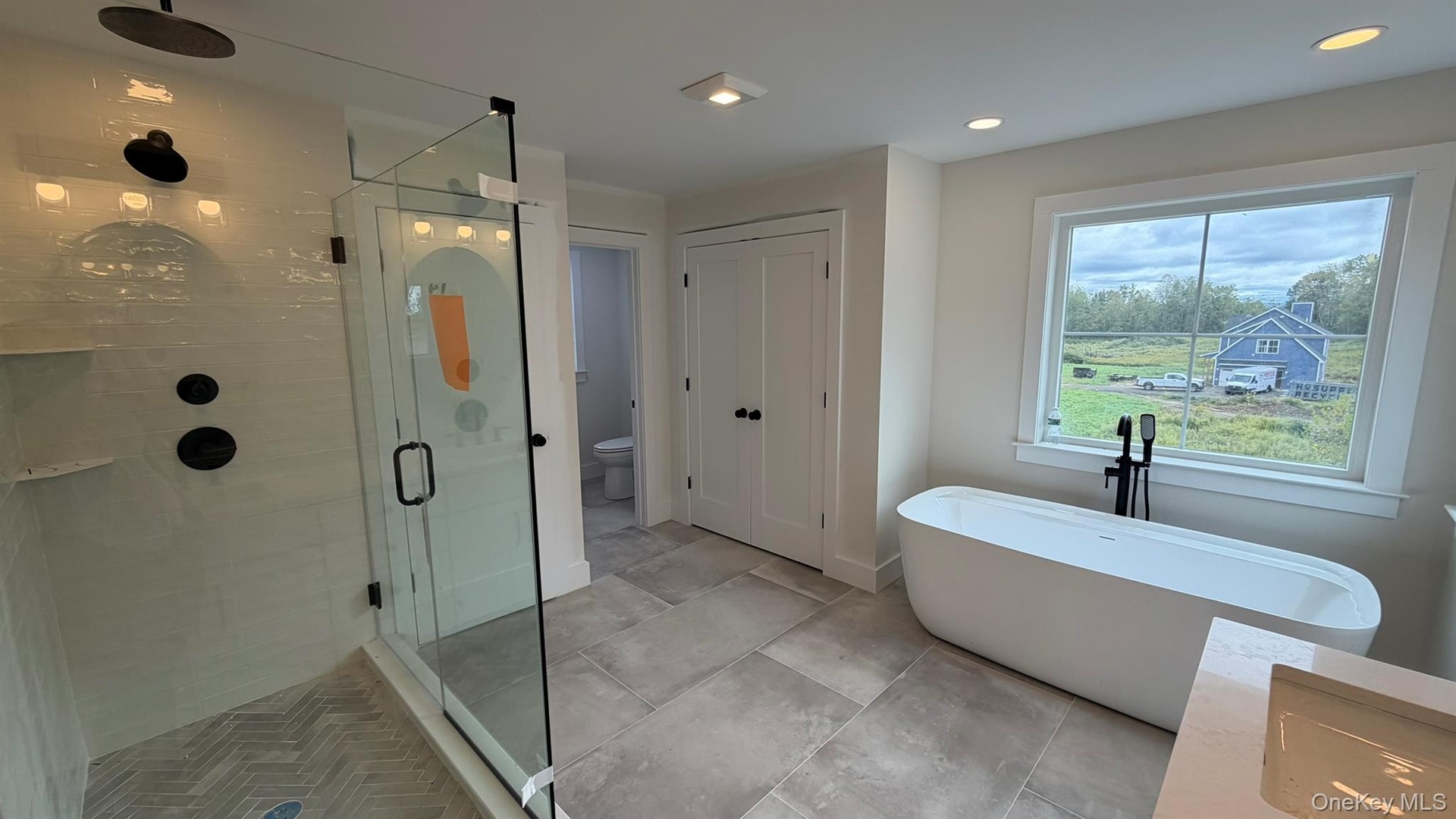 Walk-in shower taking shape with newly installed glass enclosure.