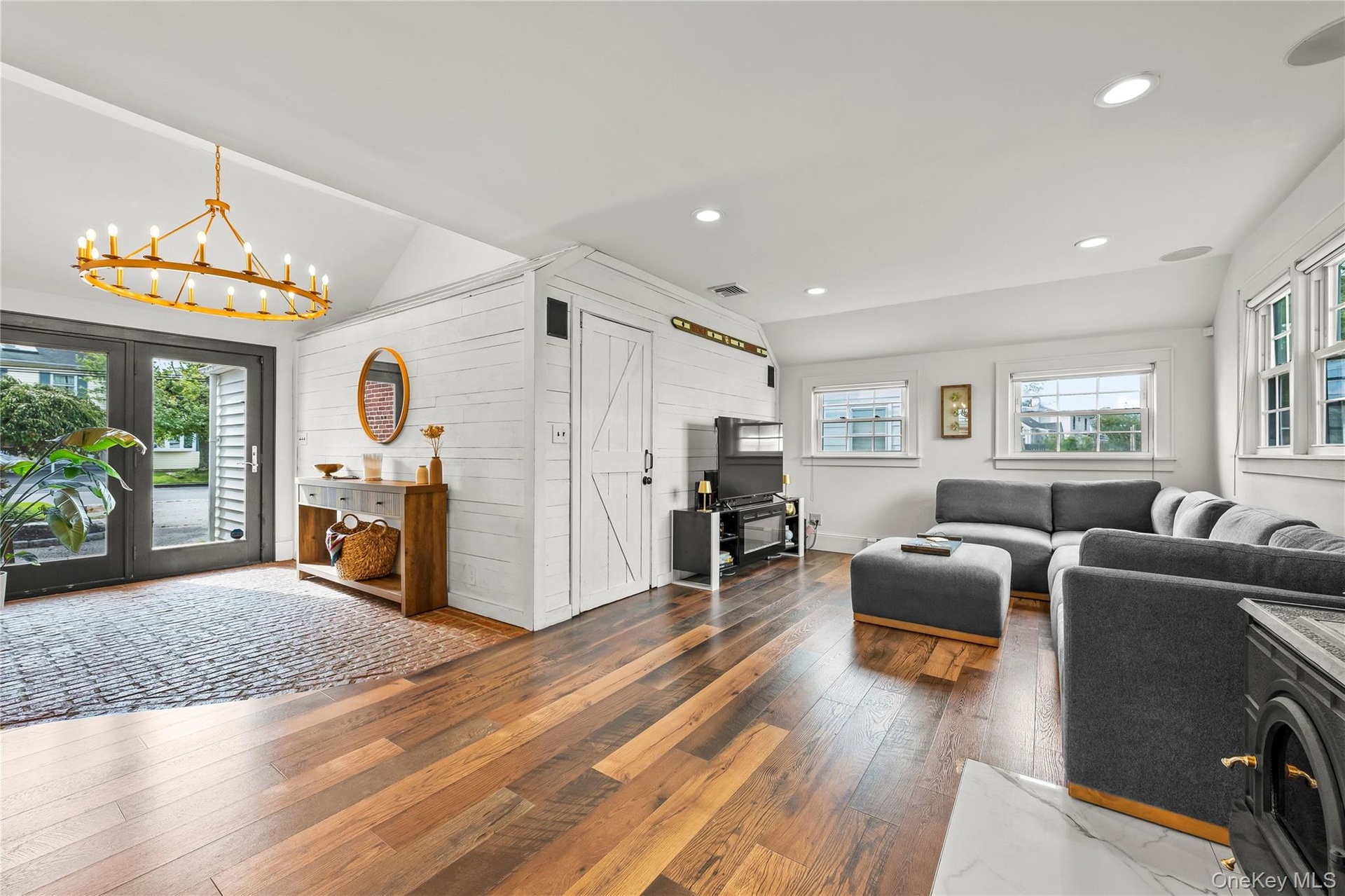 Vaulted ceilings and recessed lighting complement the wood-finish flooring