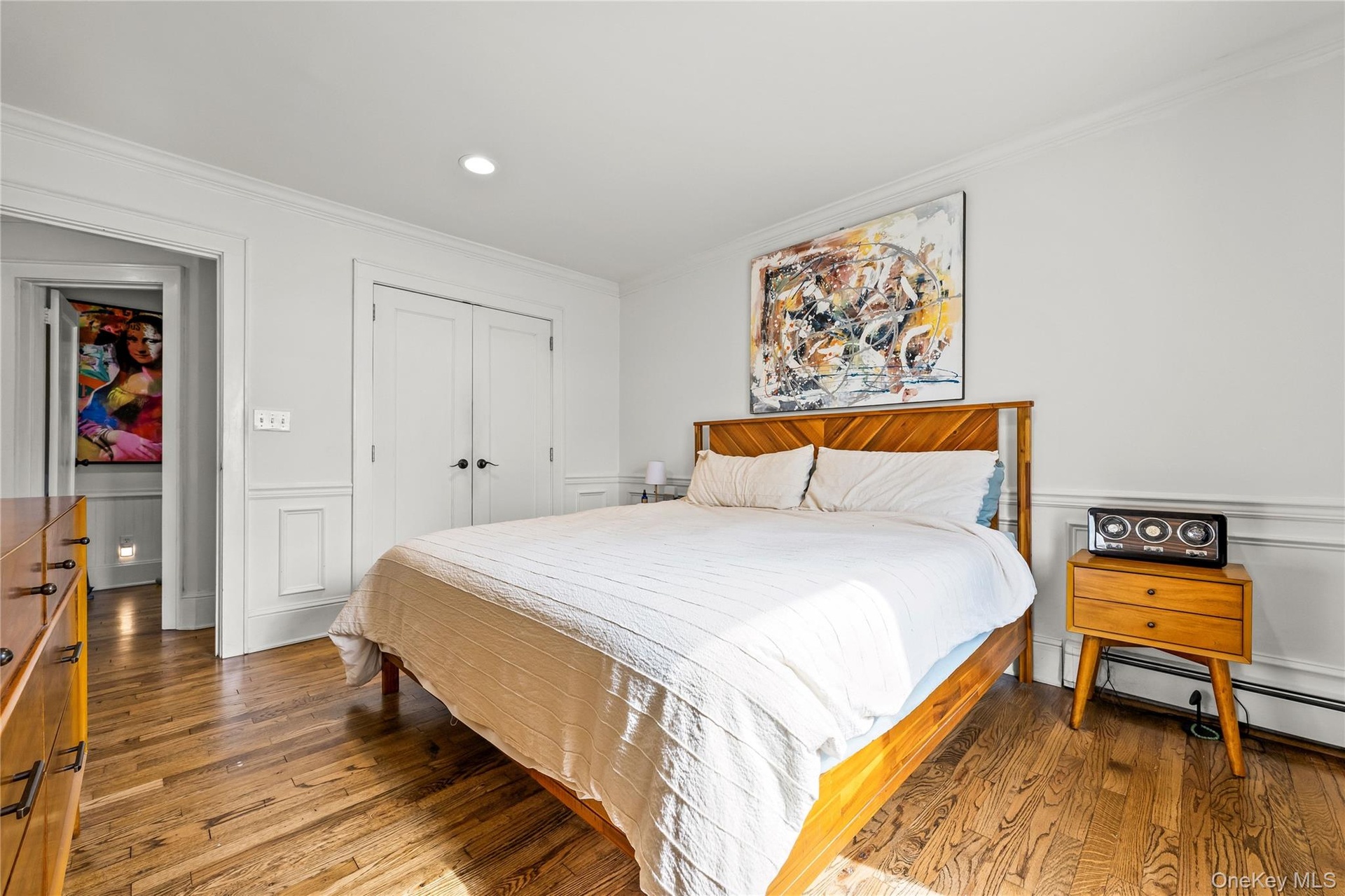 Hardwood flooring, recessed lighting, crown molding, double-door closet, and wainscoting