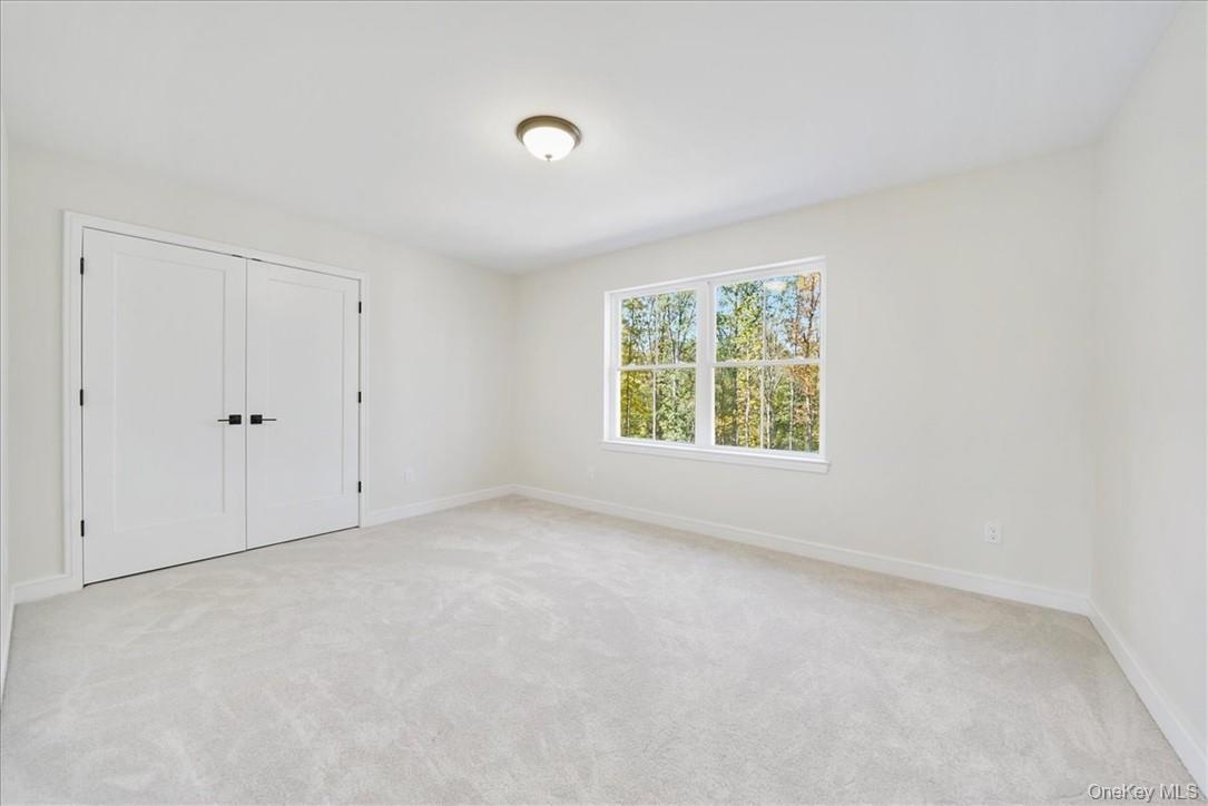 Unfurnished bedroom with light carpet and a closet