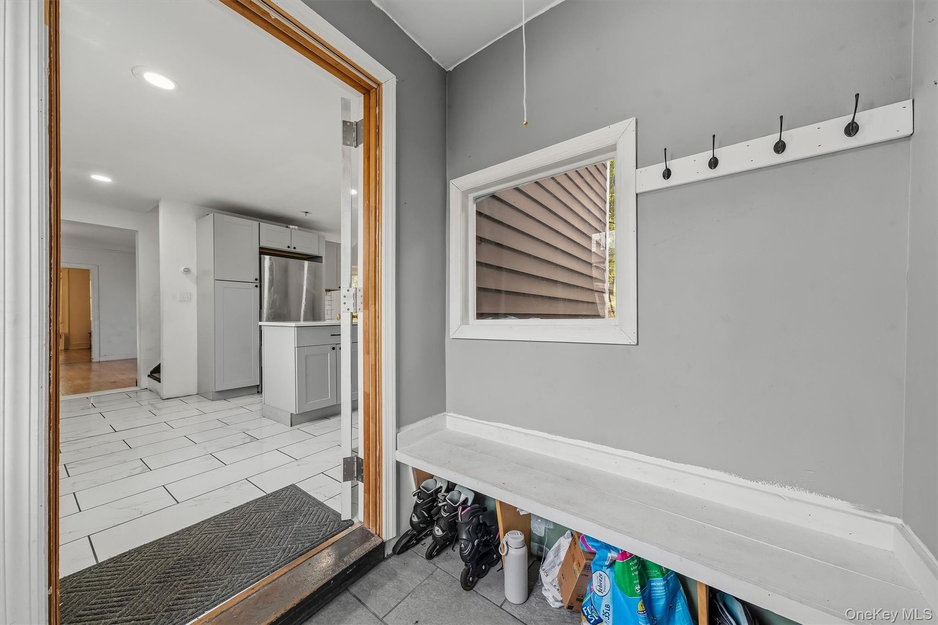 Entryway featuring built-in bench seating, storage cubbies, and wall-mounted coat hooks