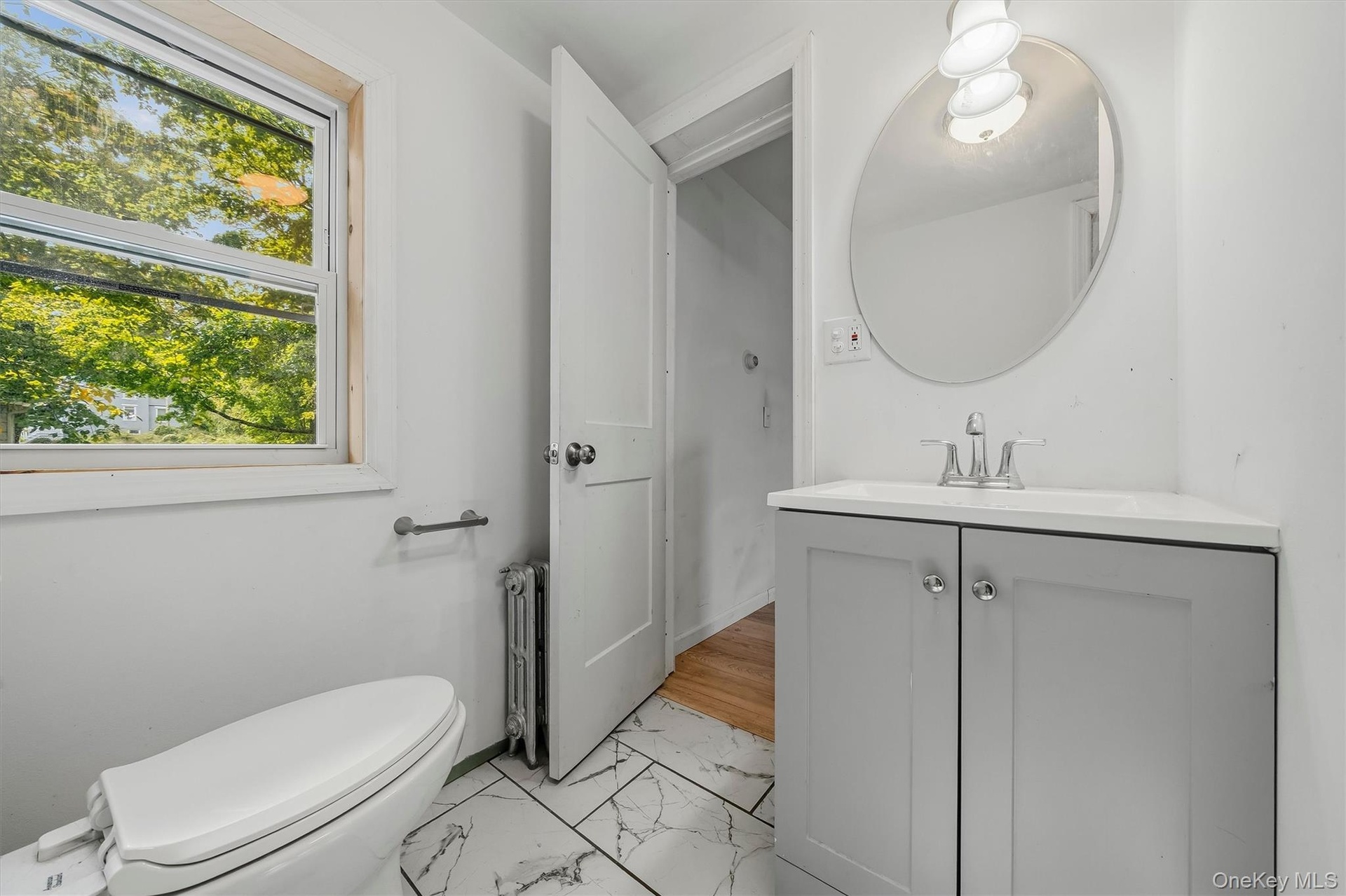 White vanity with a corner-fit countertop and undermount sink