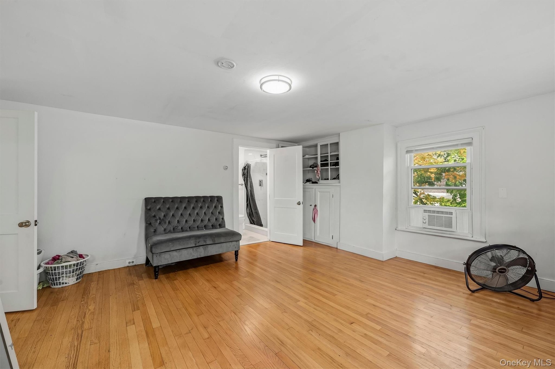 Wood-finish flooring with white walls and a built-in storage cabinet