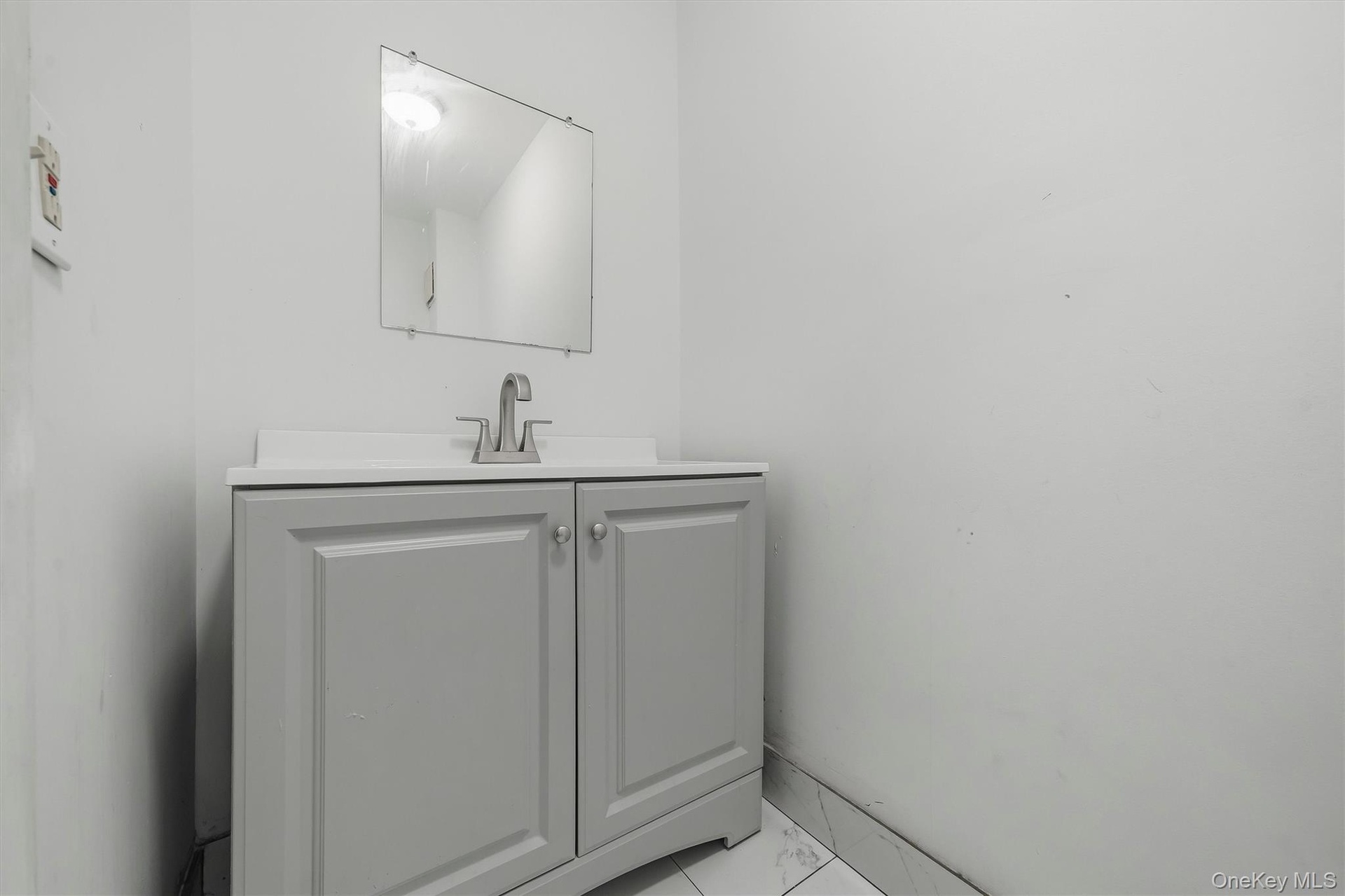 Freestanding vanity with panel cabinetry and brushed nickel hardware