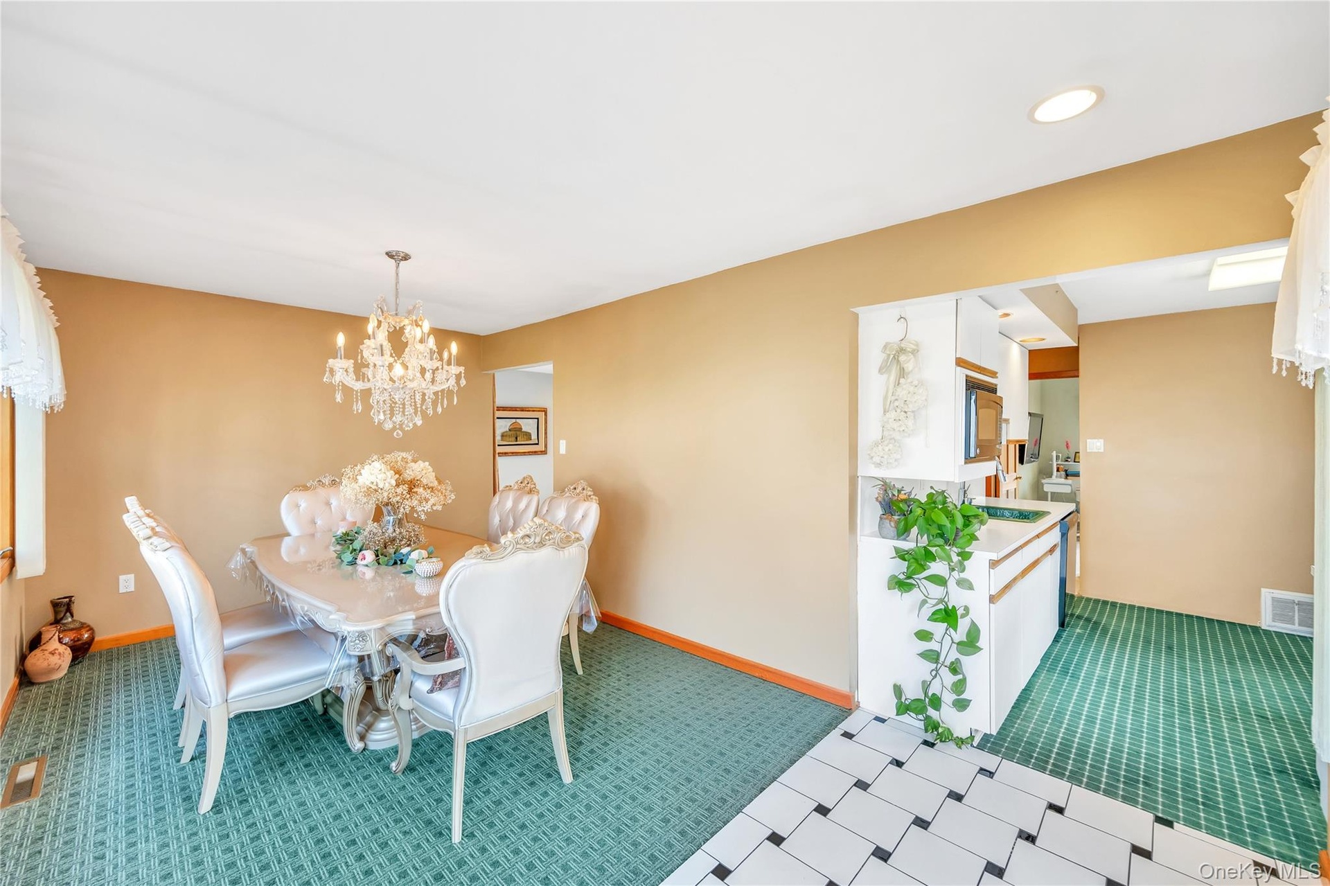 Carpeted dining area featuring a chandelier and recessed lighting
