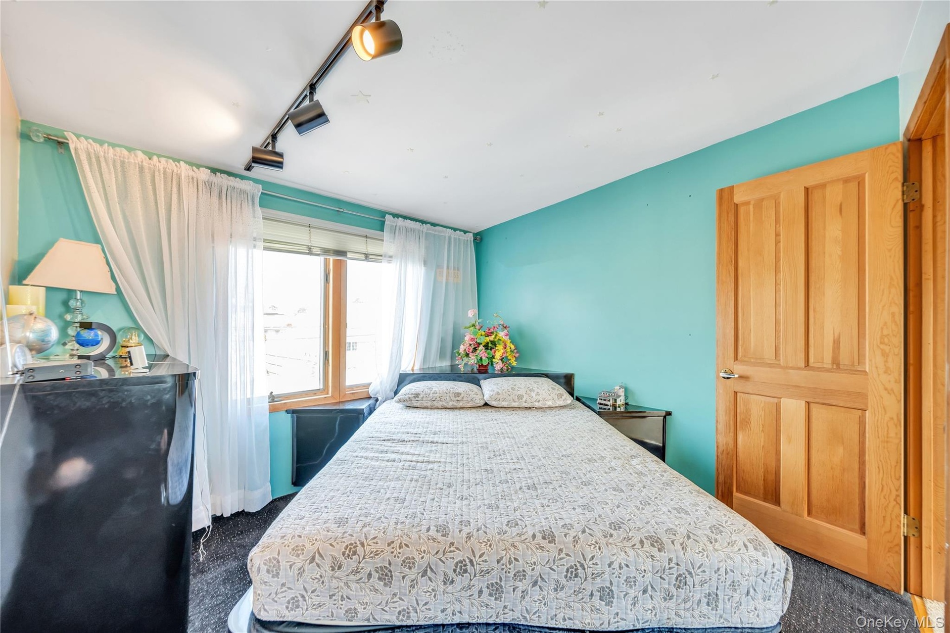 Bedroom with dark carpet and track lighting