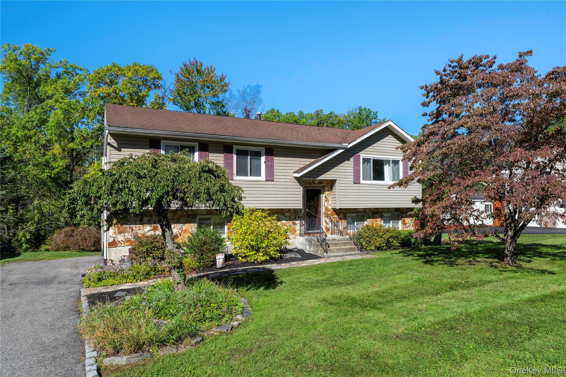 3 Bedroom home featuring stone and siding exterior, a brown shingle roof, and a paved driveway