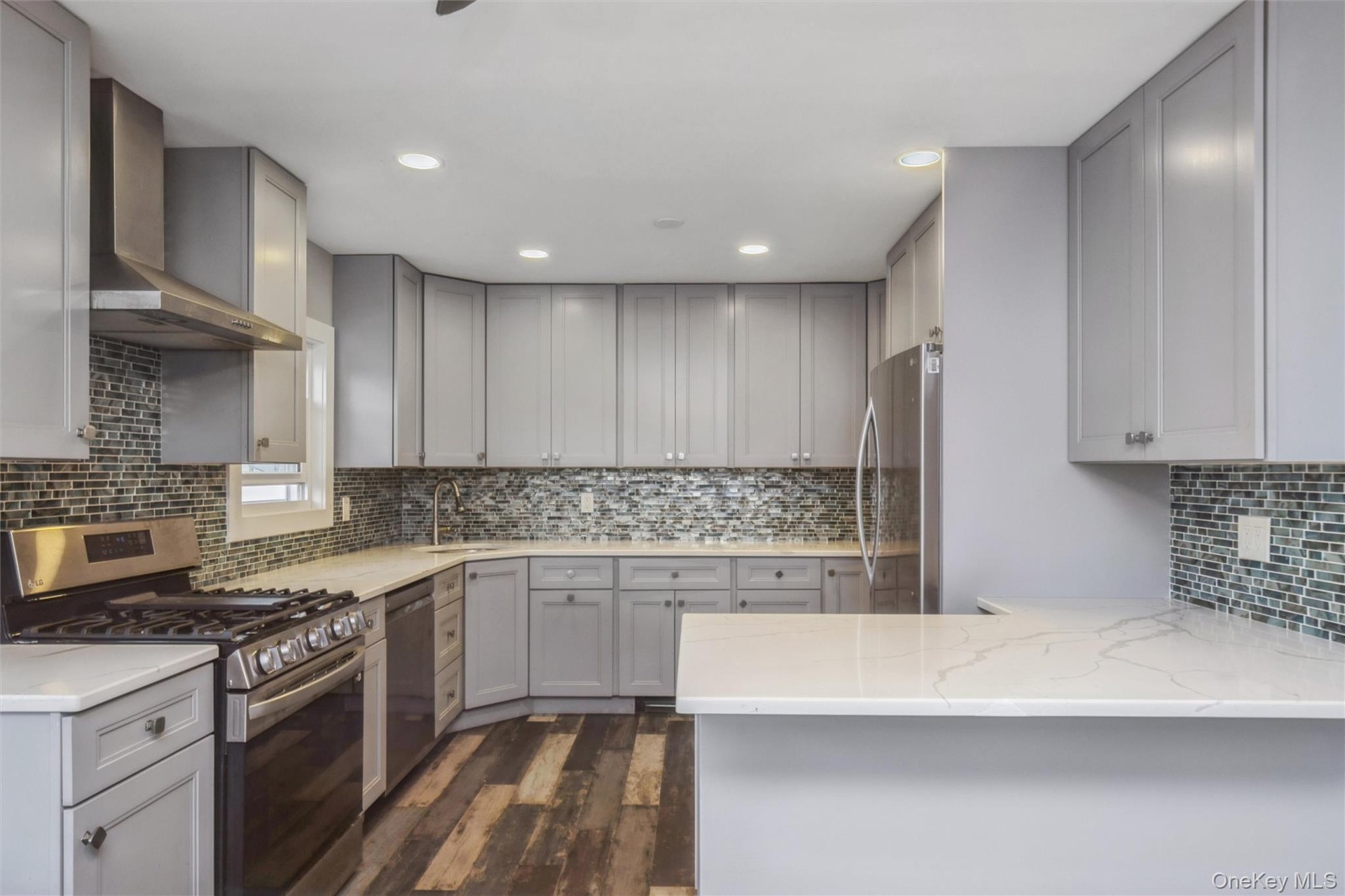 First floor renovated kitchen with quartz counter tops and stainless steel appliances.