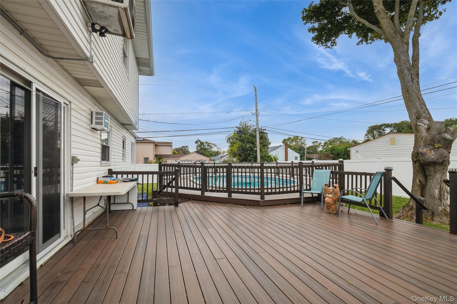Deck next to permitted partially inground pool with fence and trek decking surrounding